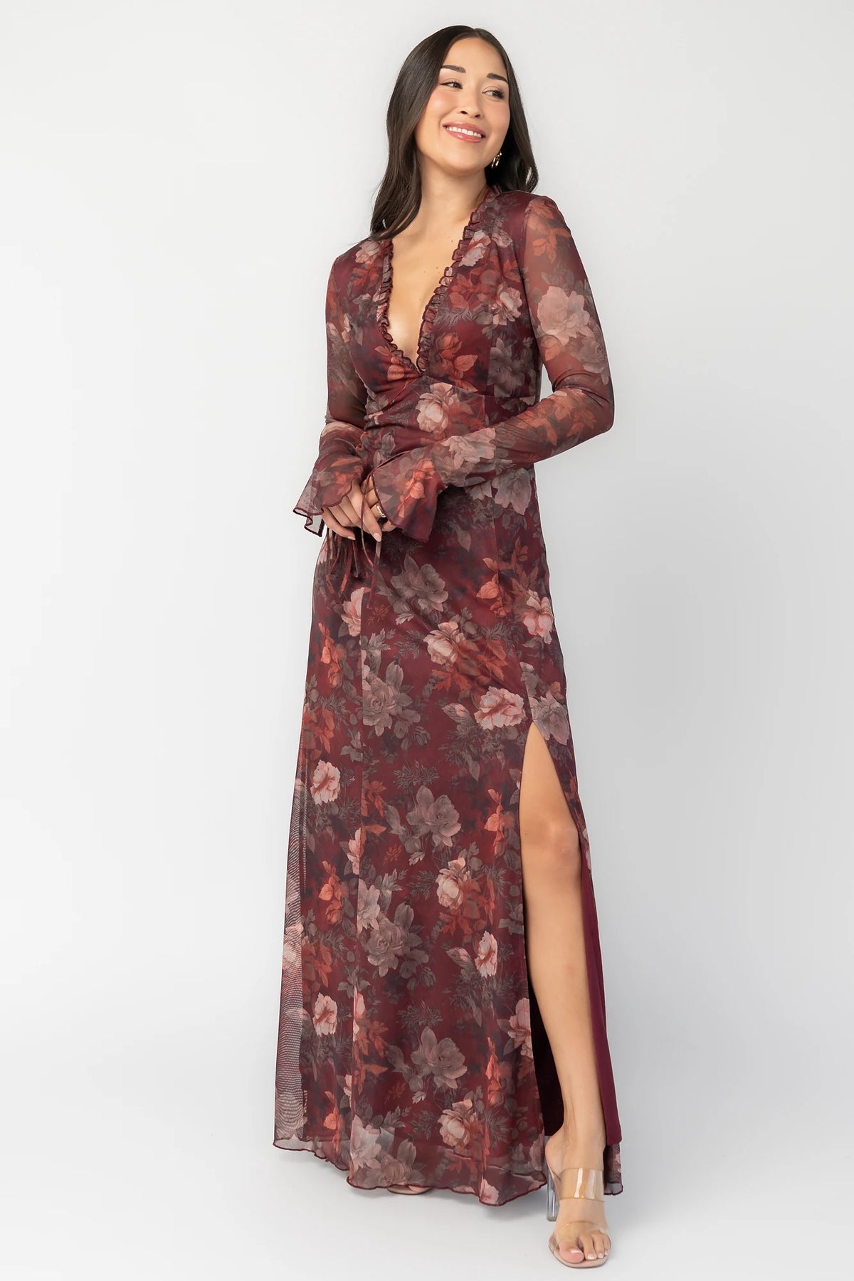 Julietta Maxi Dress in Mahogany Rose Floral with plunging V-neck, sheer long sleeves, ruffle trim, and leg slit.