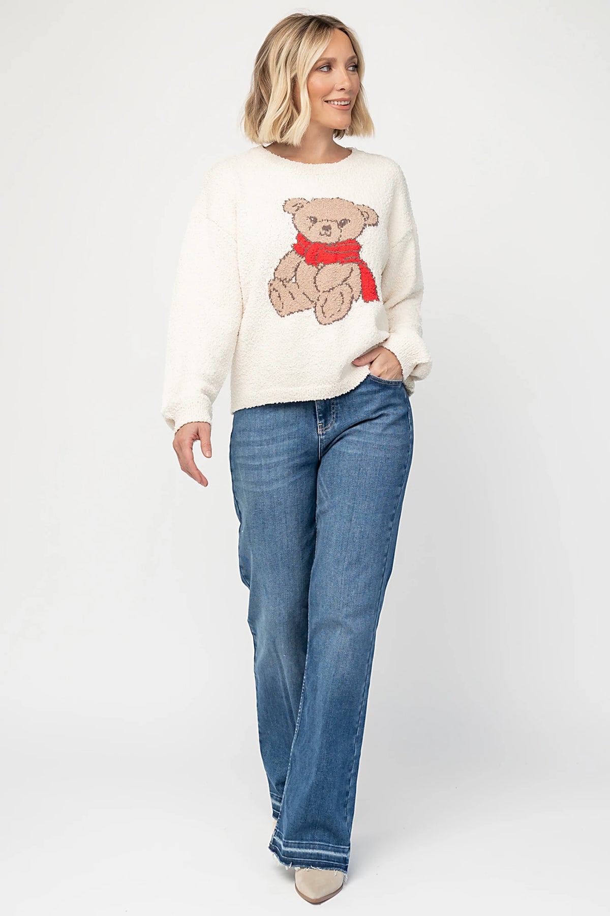 Junie Cozy Bear Sweater in Ivory with teddy bear graphic, red scarf, crew neckline, and ribbed trim.