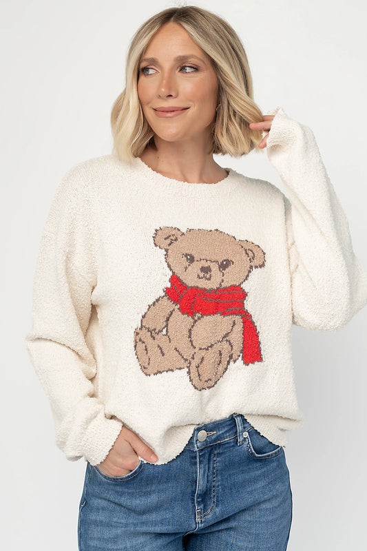 Junie Cozy Bear Sweater in Ivory with teddy bear graphic, red scarf, crew neckline, and ribbed trim.