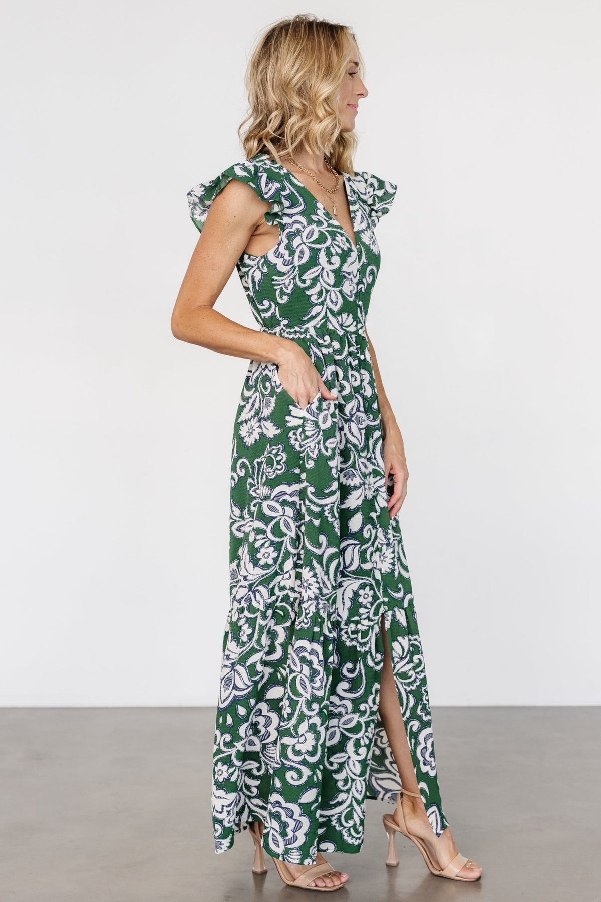 Close-up of bodice and functional front buttons on Kaia Button Maxi Dress, highlighting lined interior and cream and navy botanical motifs on green background.