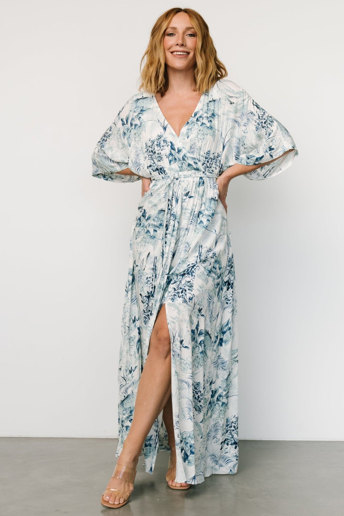 Model wearing Kalea maxi dress in blue and white print, showing flowy kimono sleeves and relaxed, maternity-friendly silhouette.