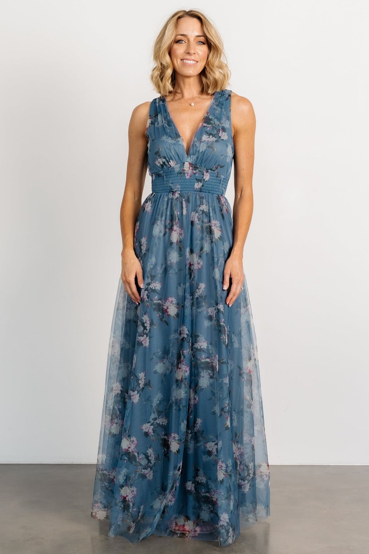 Front view of Kamila Tulle Maxi Dress in Blue Multi Floral on model, showing deep V-neck, smocked waist, and flowing tulle skirt, formal look.