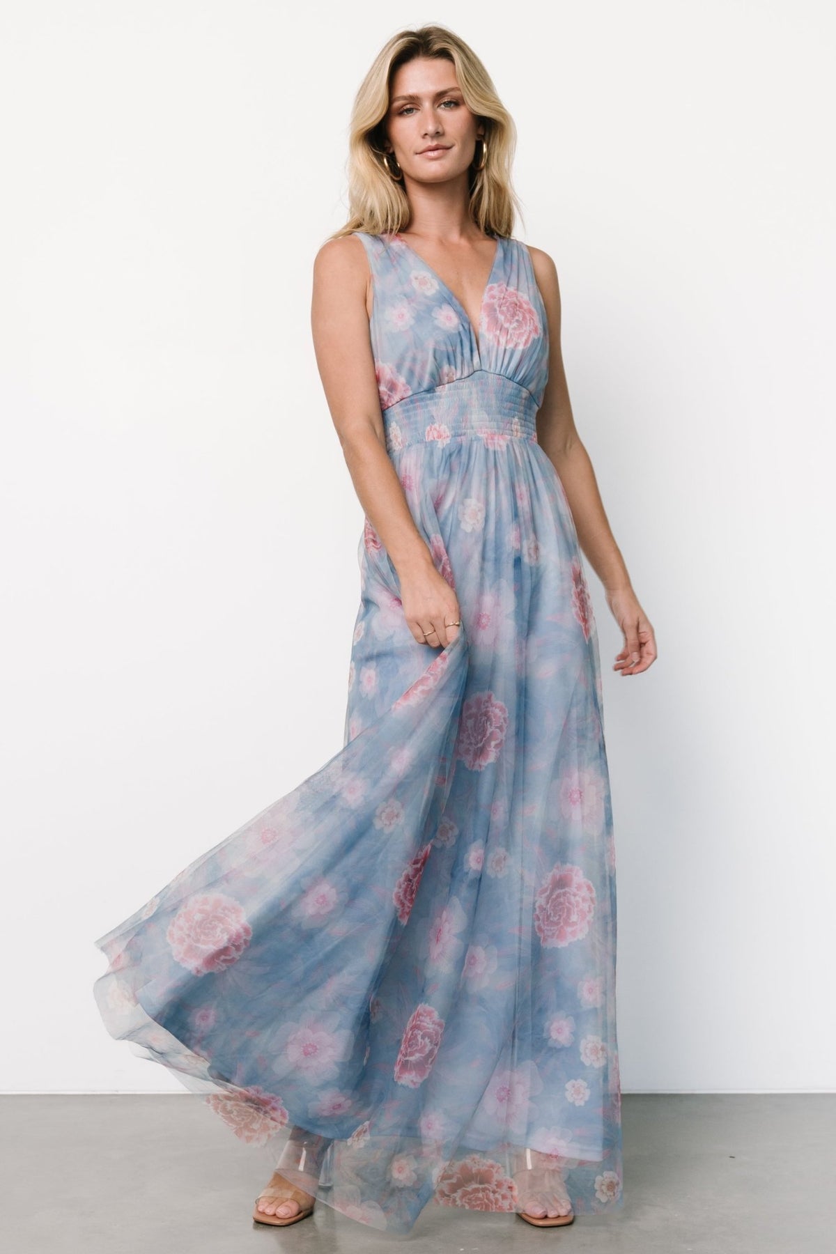 Detail shot of floral tulle fabric and stitching on light blue dress, highlighting print and layered tulle texture.