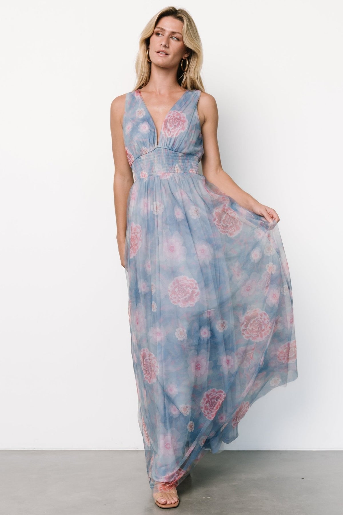 Light blue tulle maxi dress with pink floral print, deep V-neck, smocked waist and fully lined flowing skirt, model wearing size S.