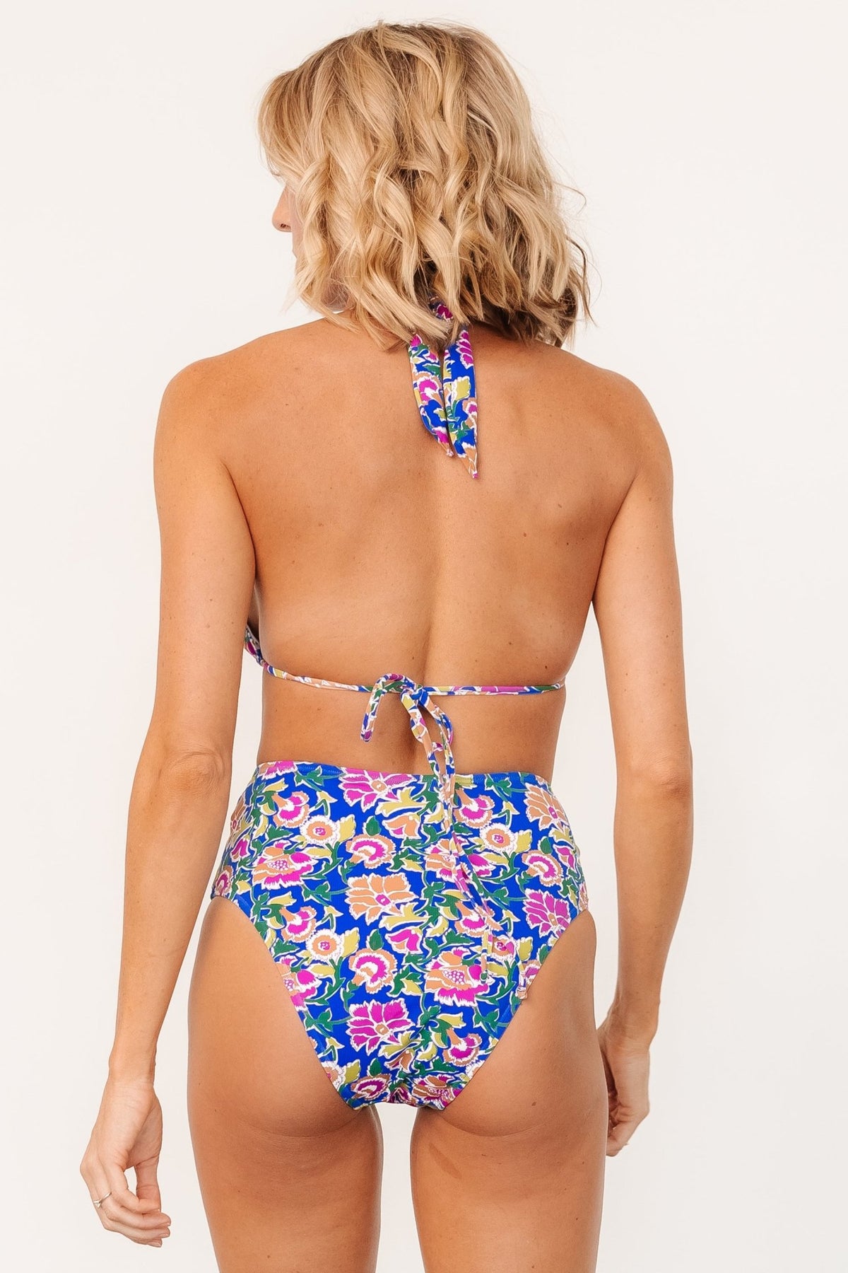 Close-up view of blue multi floral bikini bottom showing front knot, fabric texture and soft stretch construction with full lining.