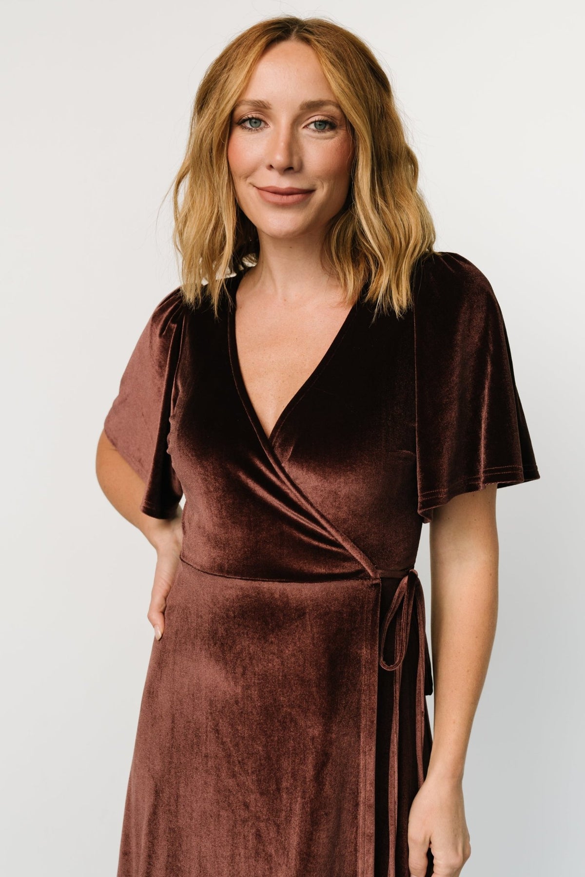 Back and hem detail of the Katelyn wrap dress in clove, showing full length, flow of fabric, and how the skirt overlaps in tulip style.