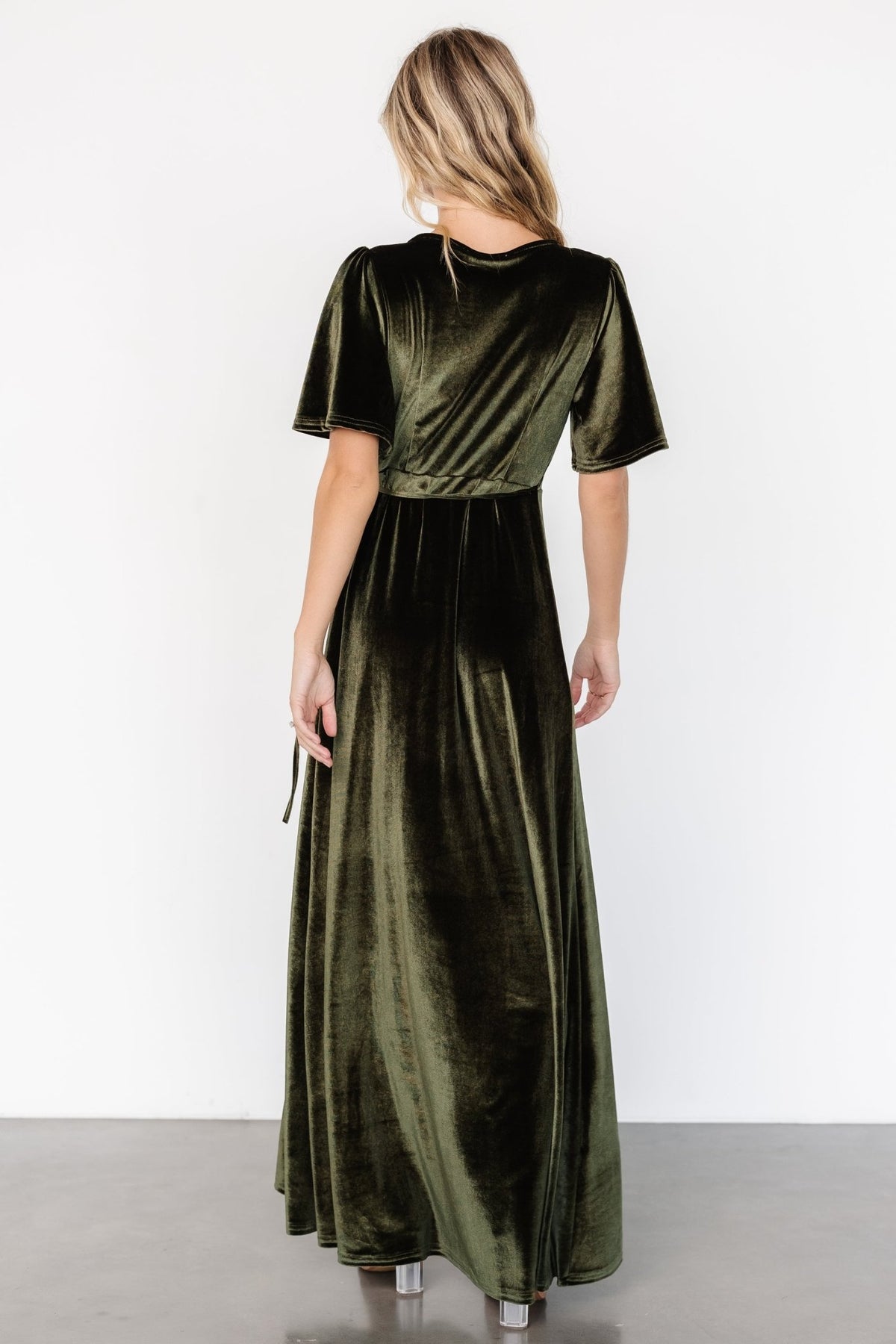 Close-up of the V-neck and bodice of the Katelyn Velvet Maxi Wrap Dress in dark olive, illustrating neckline coverage and fabric finish.