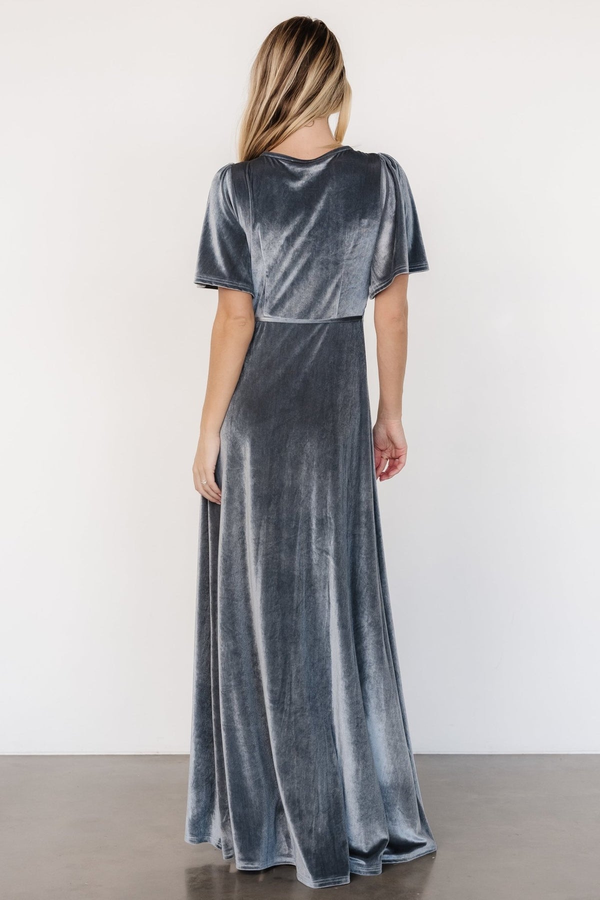Back and side view of the velvet maxi wrap dress showing hemline, fitted waist when tied, and overall length with styling suggestions for formal occasions.