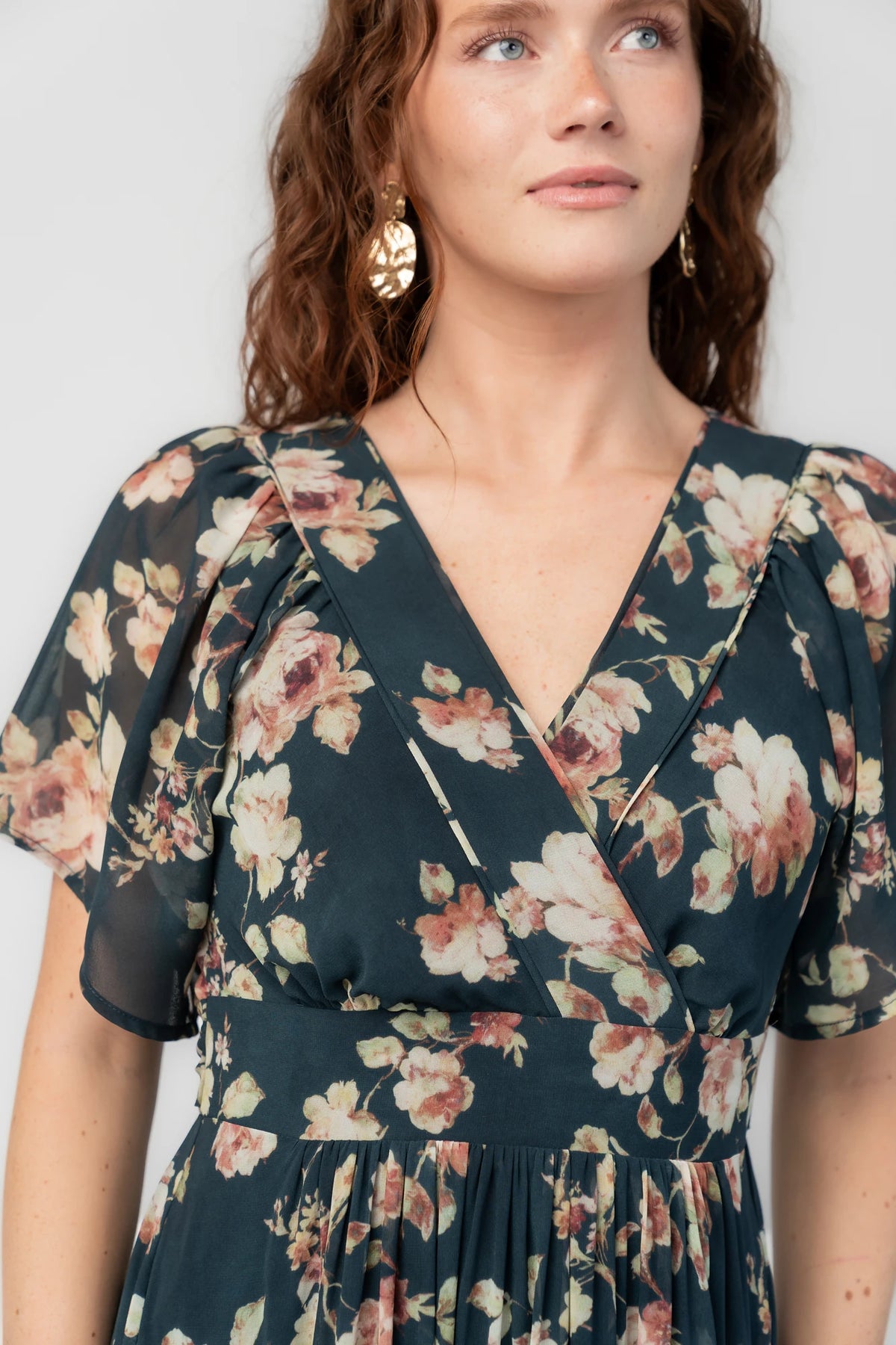Katherine Maxi Dress in Deep Blue Floral with surplice V-neck, flutter sleeves, adjustable waist ties, and tiered skirt.
