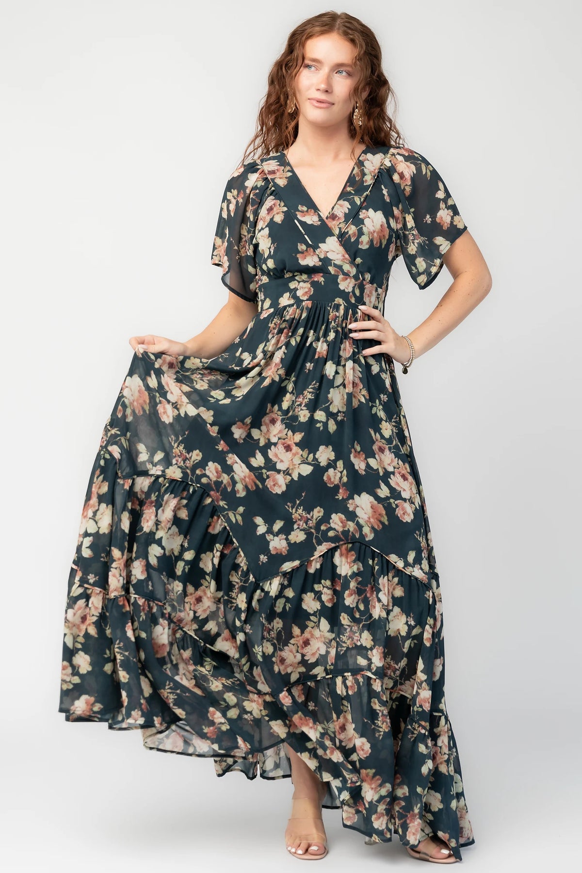 Katherine Maxi Dress in Deep Blue Floral with surplice V-neck, flutter sleeves, adjustable waist ties, and tiered skirt.