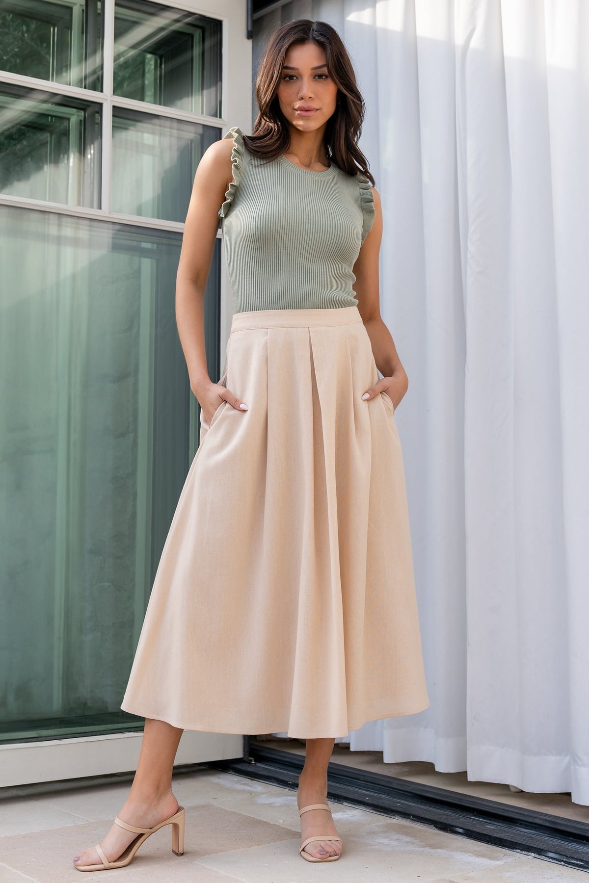 Close-up of skirt fabric texture and pleats in natural shade, highlighting rayon-linen weave and tailored stitch details at the waist.