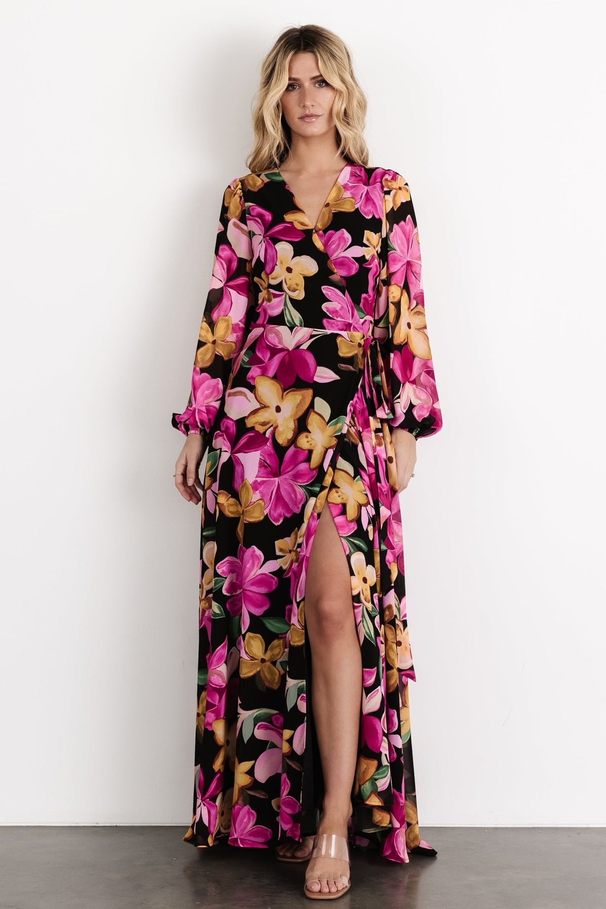 Three-quarter front shot of the Katinka Wrap Maxi Dress, highlighting the floral print, bishop sleeves with elastic cuffs, and the adjustable self-tie waist.