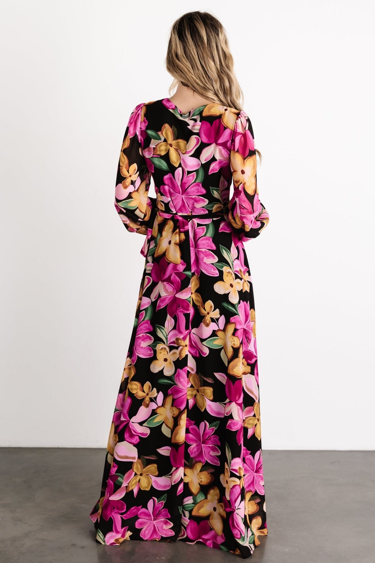 Lifestyle shot of the Katinka Wrap Maxi Dress styled for travel and resort wear, featuring the floral print and lightweight chiffon drape.
