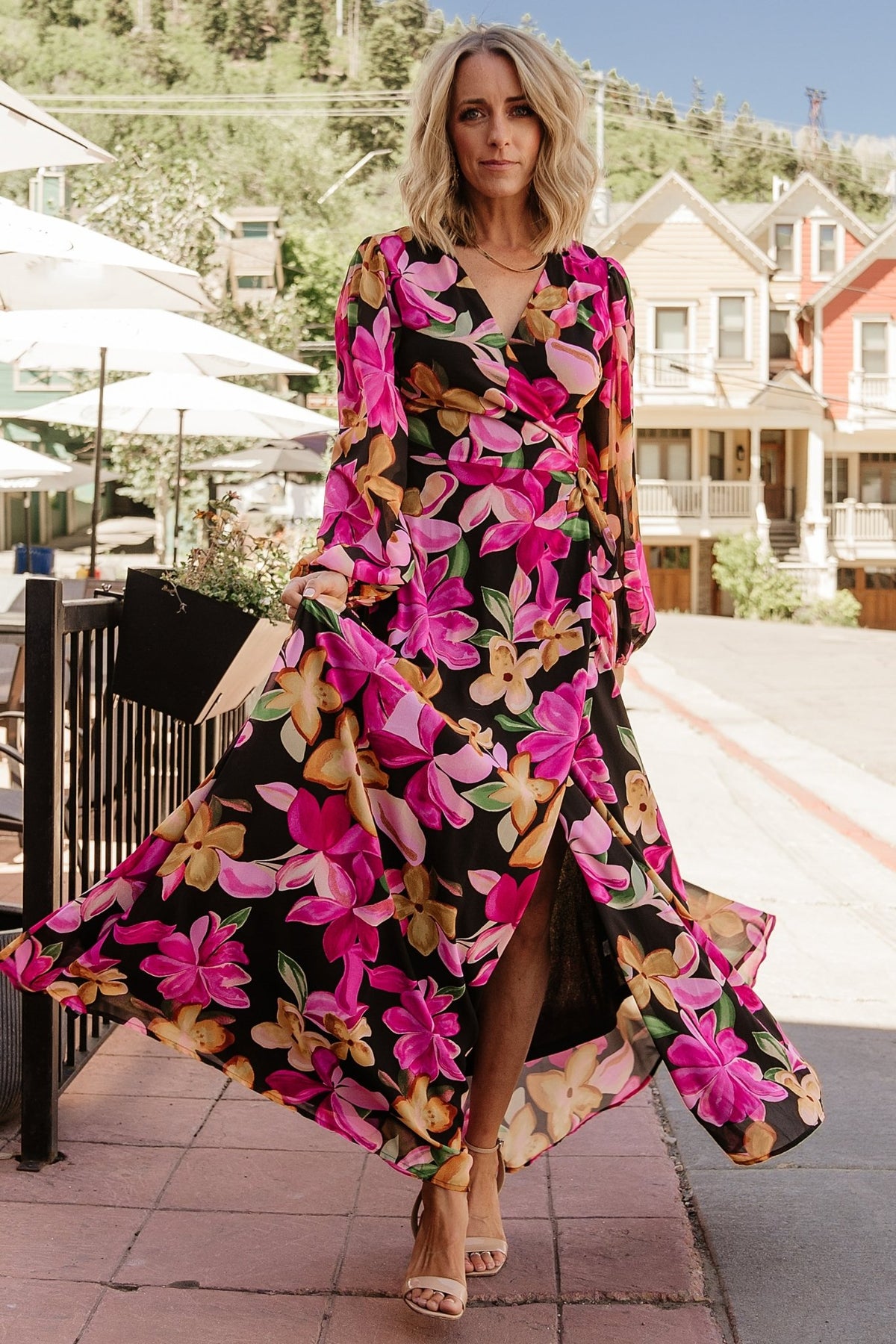Front view of the Katinka Wrap Maxi Dress in black multi floral on a model, showing full-length chiffon skirt, wrap waist tie, and surplice neckline.