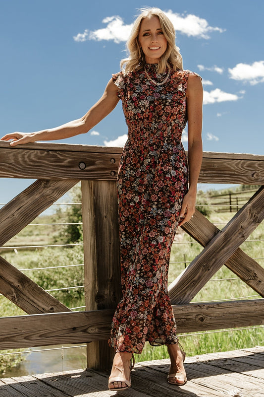 Front view of Kearny Ruffle Maxi Dress in brown multi floral on model, showing smocked high neckline, short flutter sleeves, and flowing chiffon skirt.