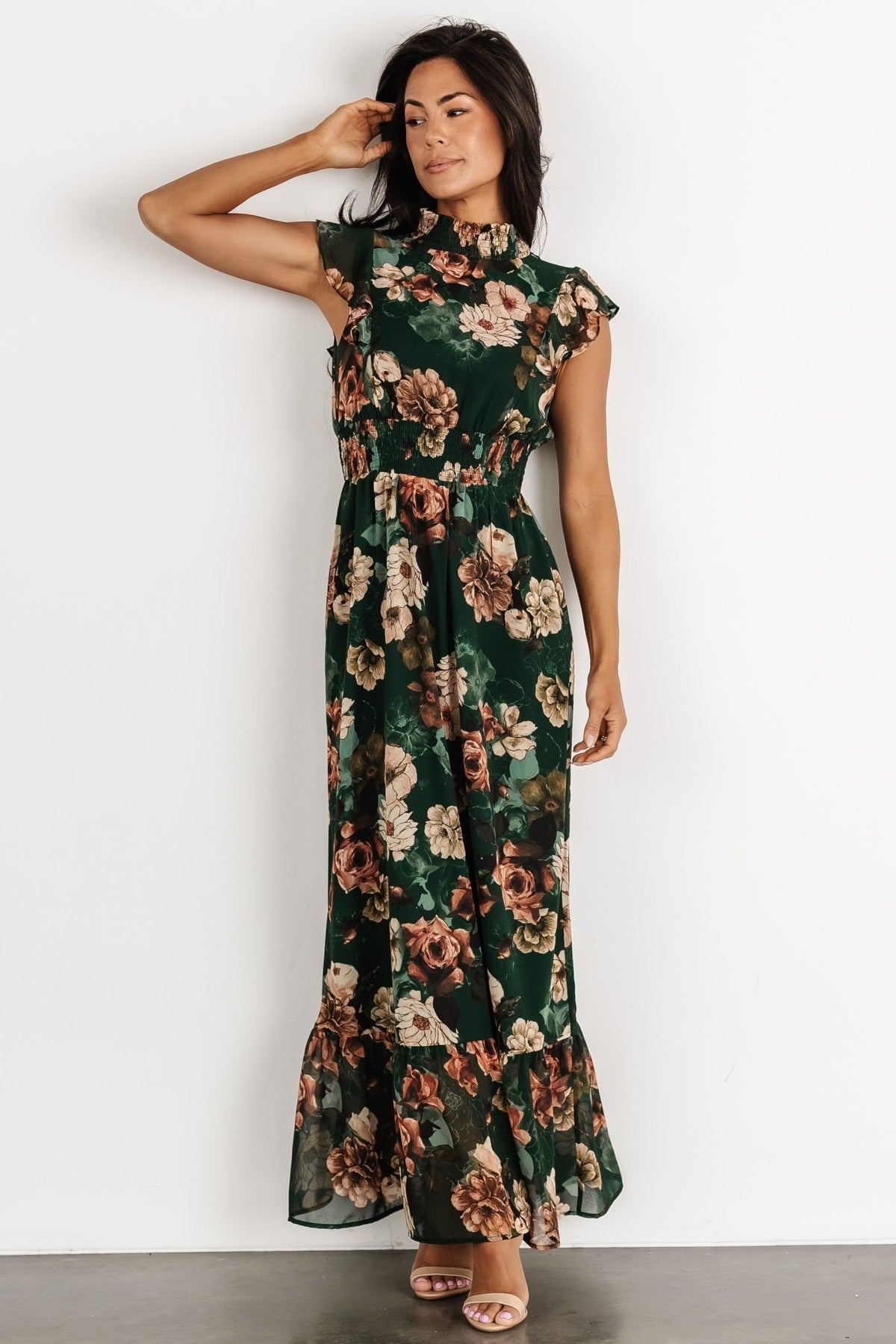 Close-up of smocked high neckline and button closure at back, showing gathered chiffon texture and floral print detail.