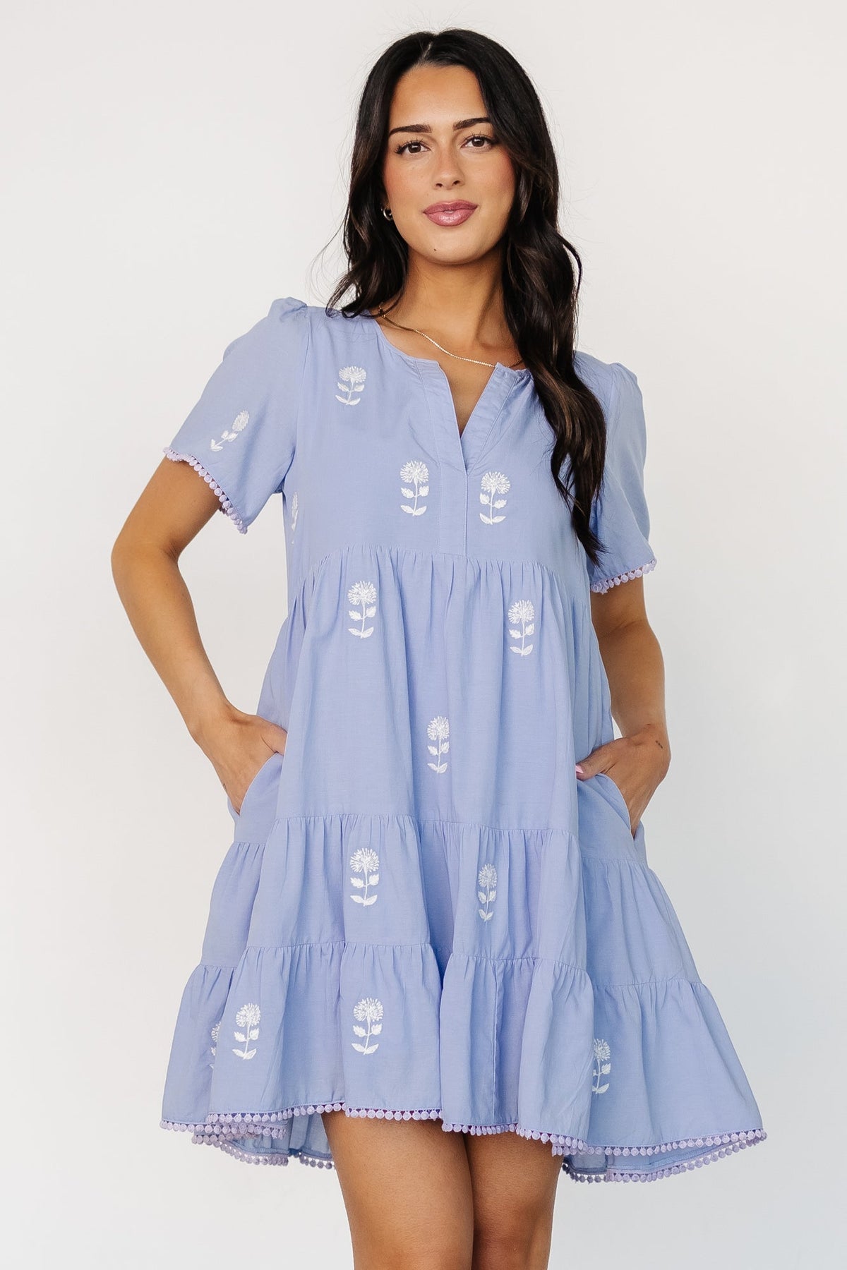 Back and three-quarter view of short tiered dress with subtle high-low hemline, polka-dot hem trim, and relaxed fit.