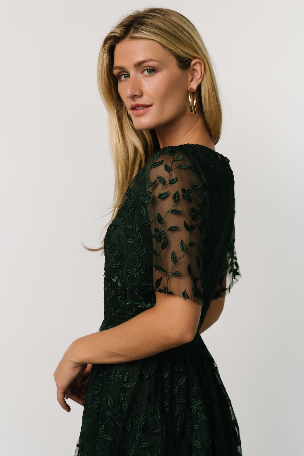 Full-length shot of Kendra embroidered midi dress worn by model, illustrating natural gathered waist, midi skirt length, and overall drape.