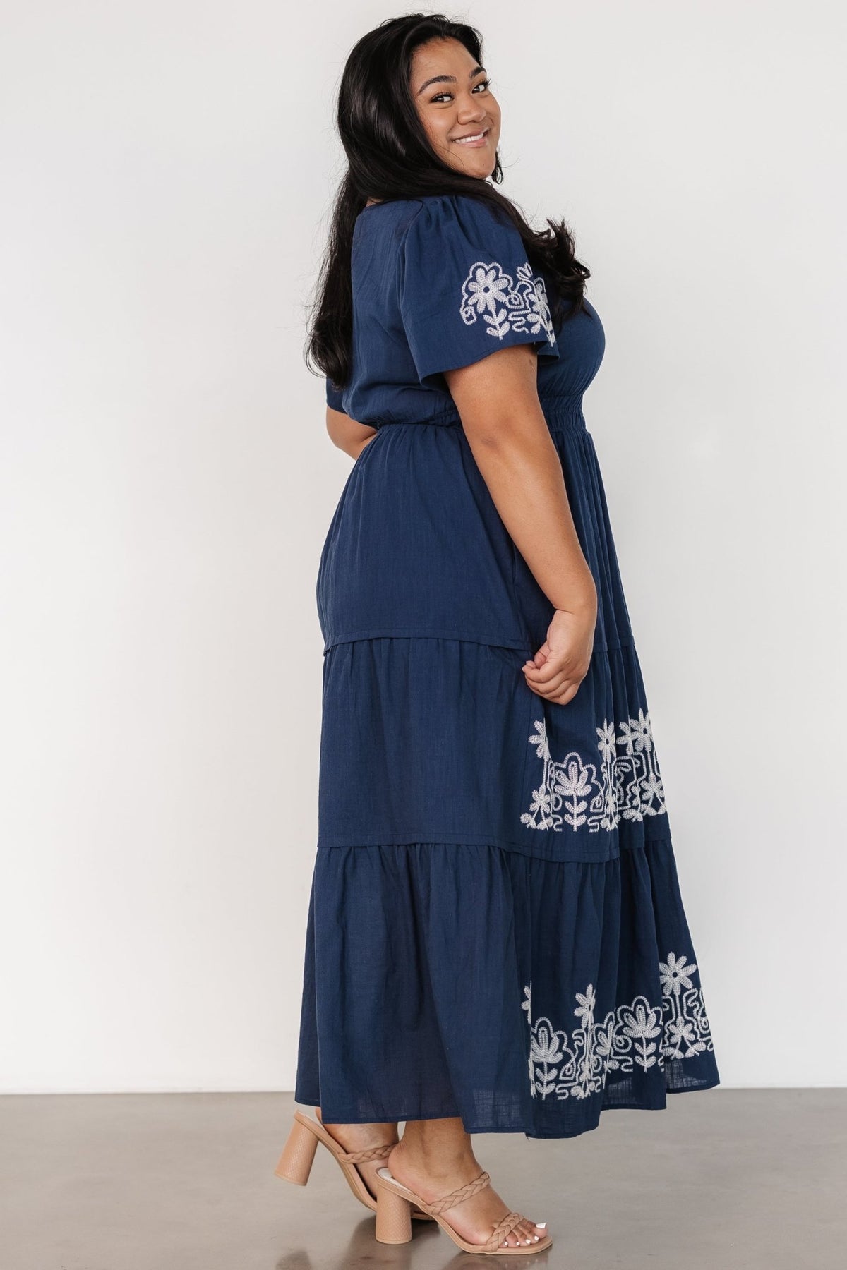 Close-up of skirt lining edge and embroidered hem detail, illustrating the lined skirt to the bottom tier and fabric composition.
