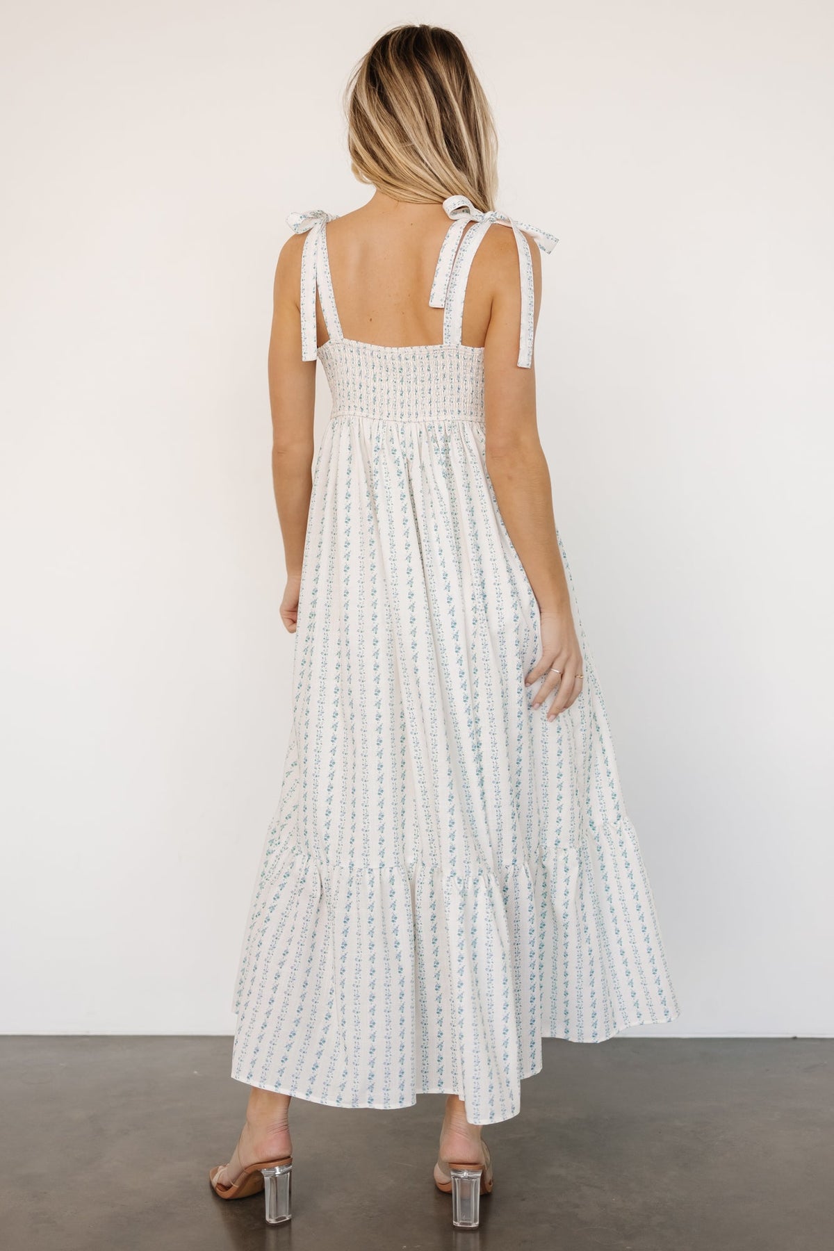 Side view of Kennie Maxi Dress in cream multi floral showing hidden side pocket, left-side zipper placement, and the knee lining under the skirt.