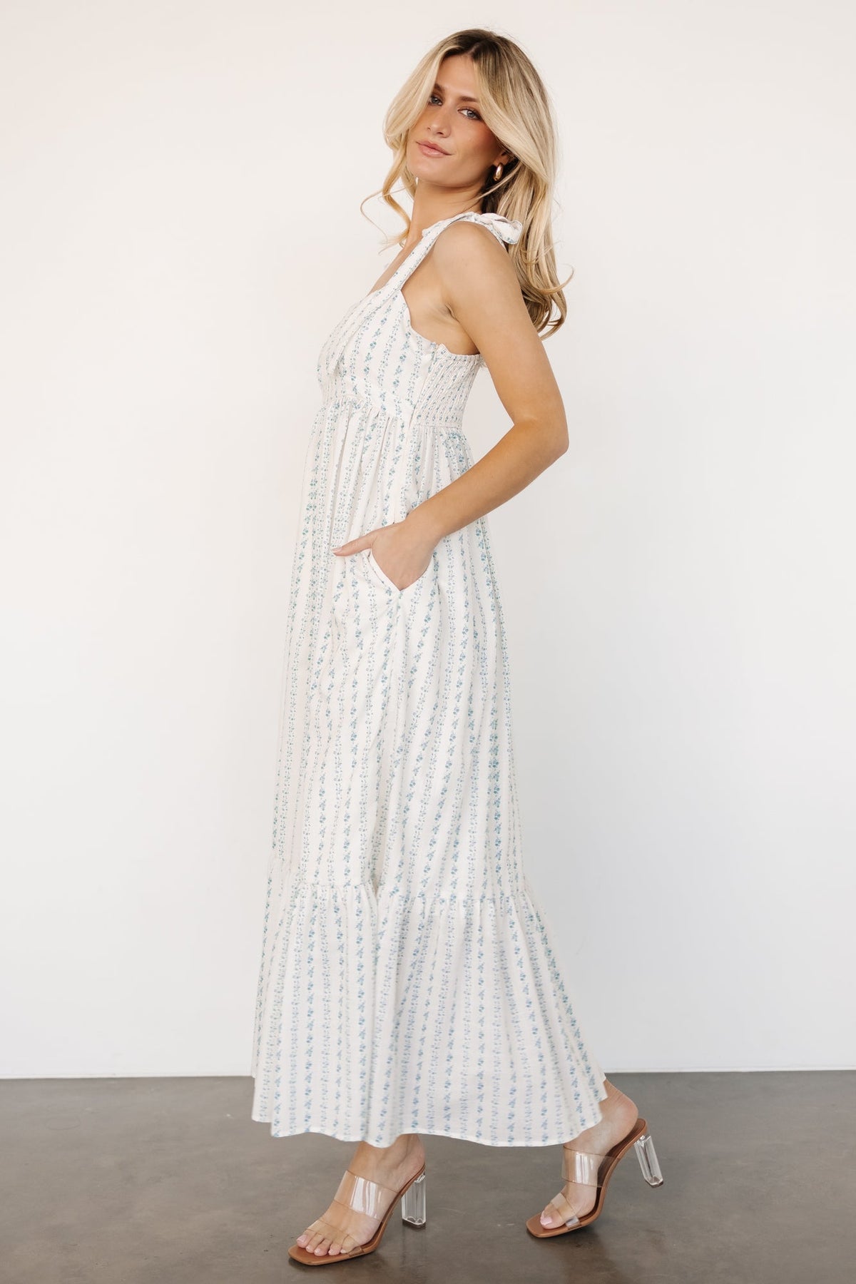 Back view of Kennie Maxi Dress highlighting smocked back panel, adjustable shoulder ties, and overall relaxed silhouette in cream multi floral print.