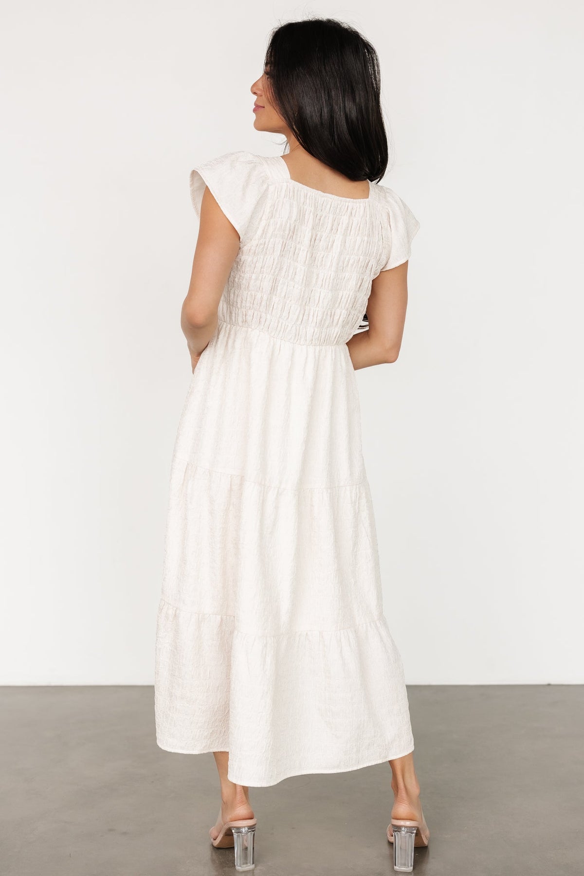 Side view of Kesler Midi Dress in cream highlighting hidden side pocket placement and gentle skirt drape.