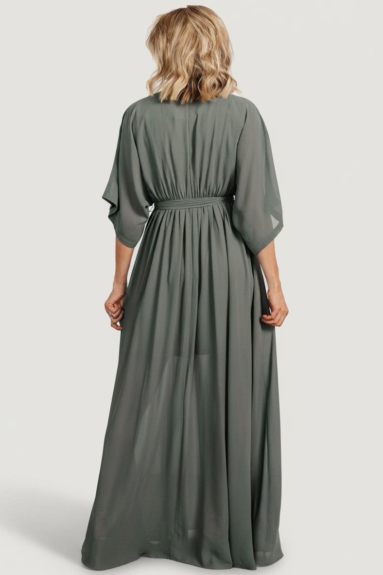 Back view of dark sage Kia kimono maxi dress on model, showing full maxi length, gentle train and unlined sleeves.