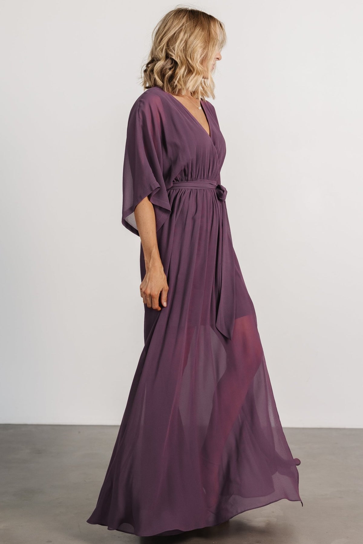 Side view of the Kia Kimono Maxi Dress in vintage plum emphasizing the left-side leg slit, flowing maxi skirt, and mid-thigh lining length.