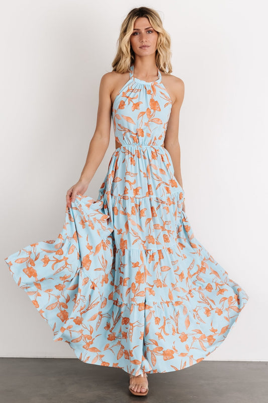 Front view of blue and orange floral tiered maxi dress on model, high neckline, adjustable neck and back ties, open-back detail visible on model.