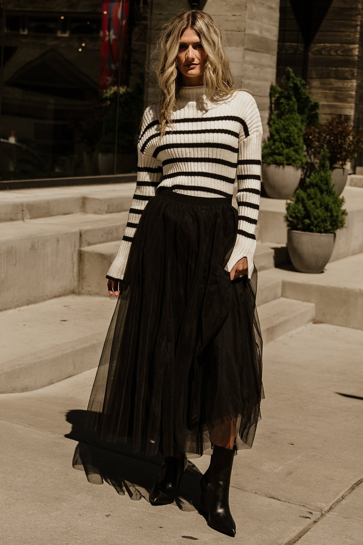 Styled flat-lay of Landell striped sweater in ivory and black, displaying mock neck, ribbed texture, and stripe alignment.