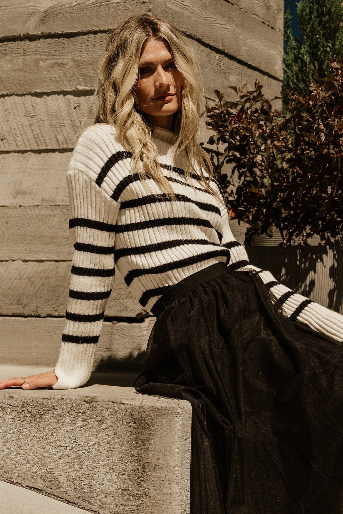 Detail shot of cuff slit and sleeve finish on Landell ribbed sweater, with clear ivory and black stripe contrast.
