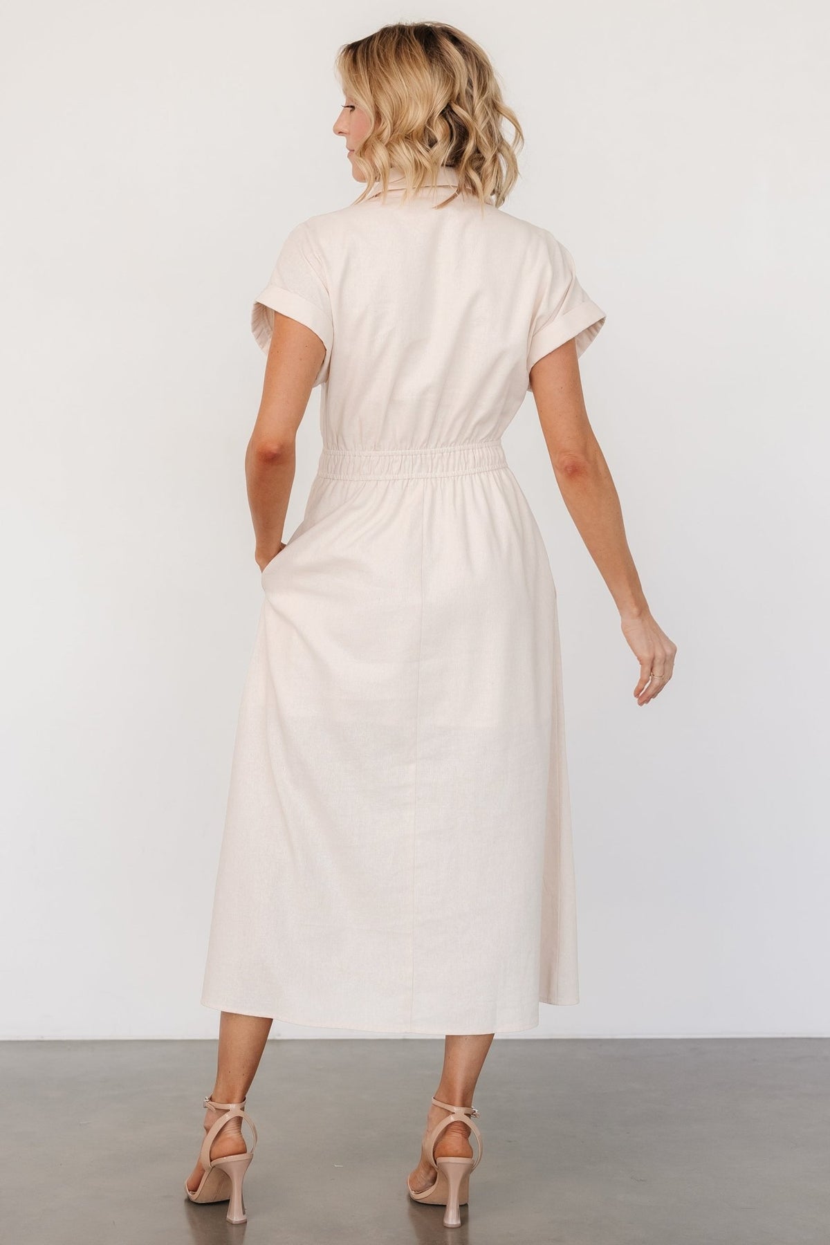 Close-up of smocked front waistband and partial lining area showing fabric drape and construction of the natural linen-cotton blend.