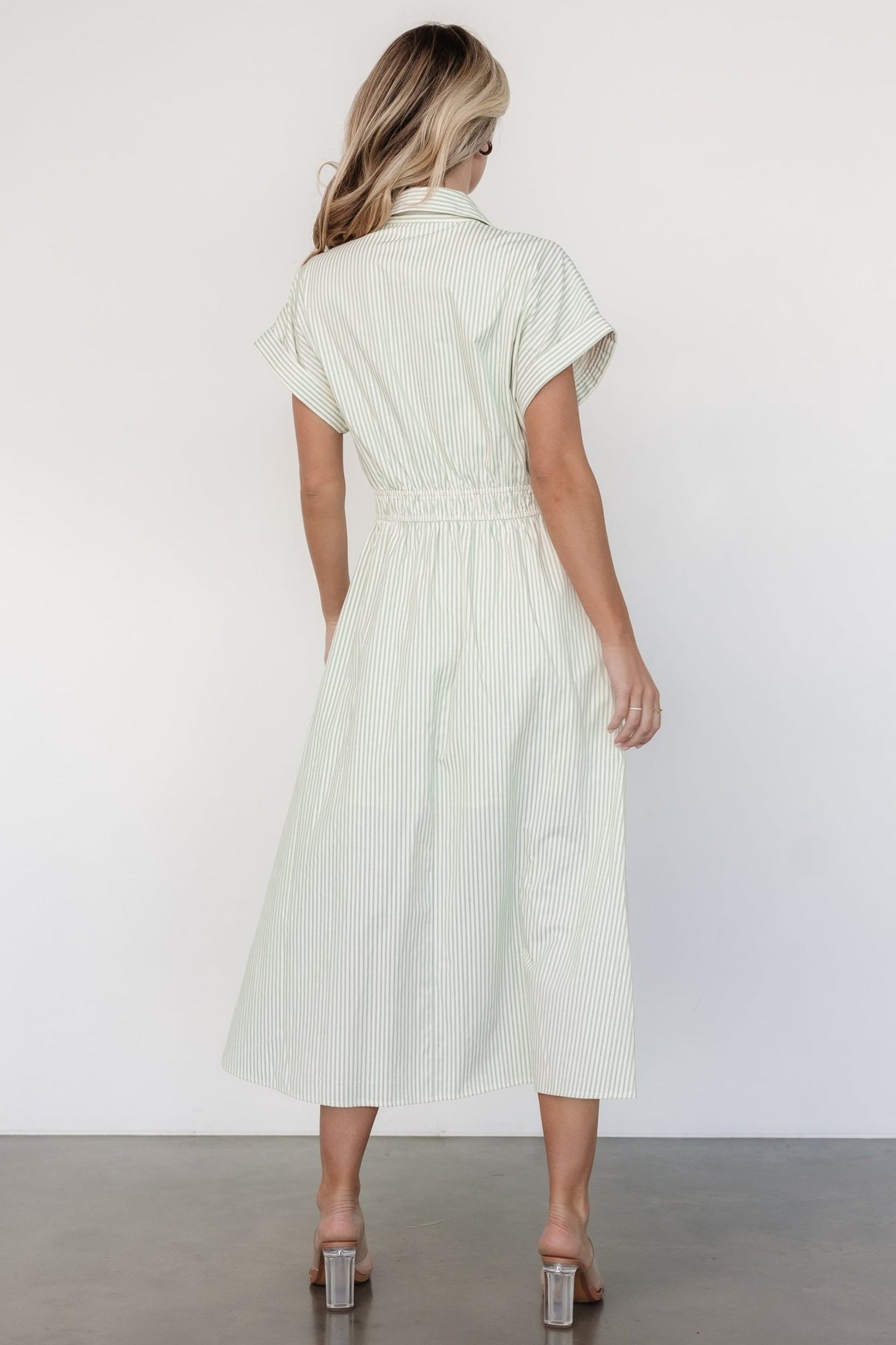 Styled flat-lay of sage and off-white striped midi dress showing collar, faux buttons, short sleeves, and partial lining.