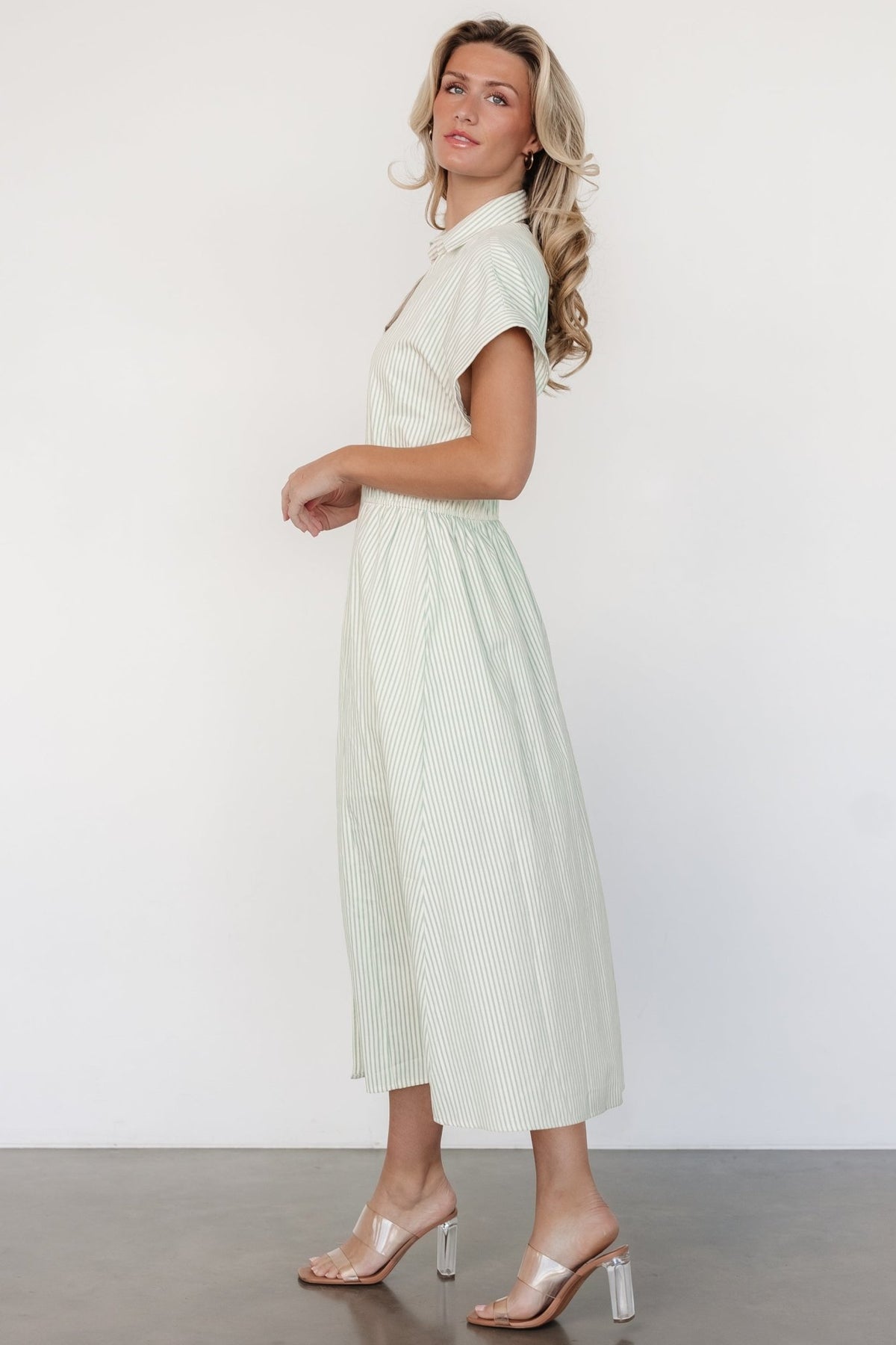 Back and side view highlighting the fully smocked back waist and gentle flare of the sage striped midi dress.