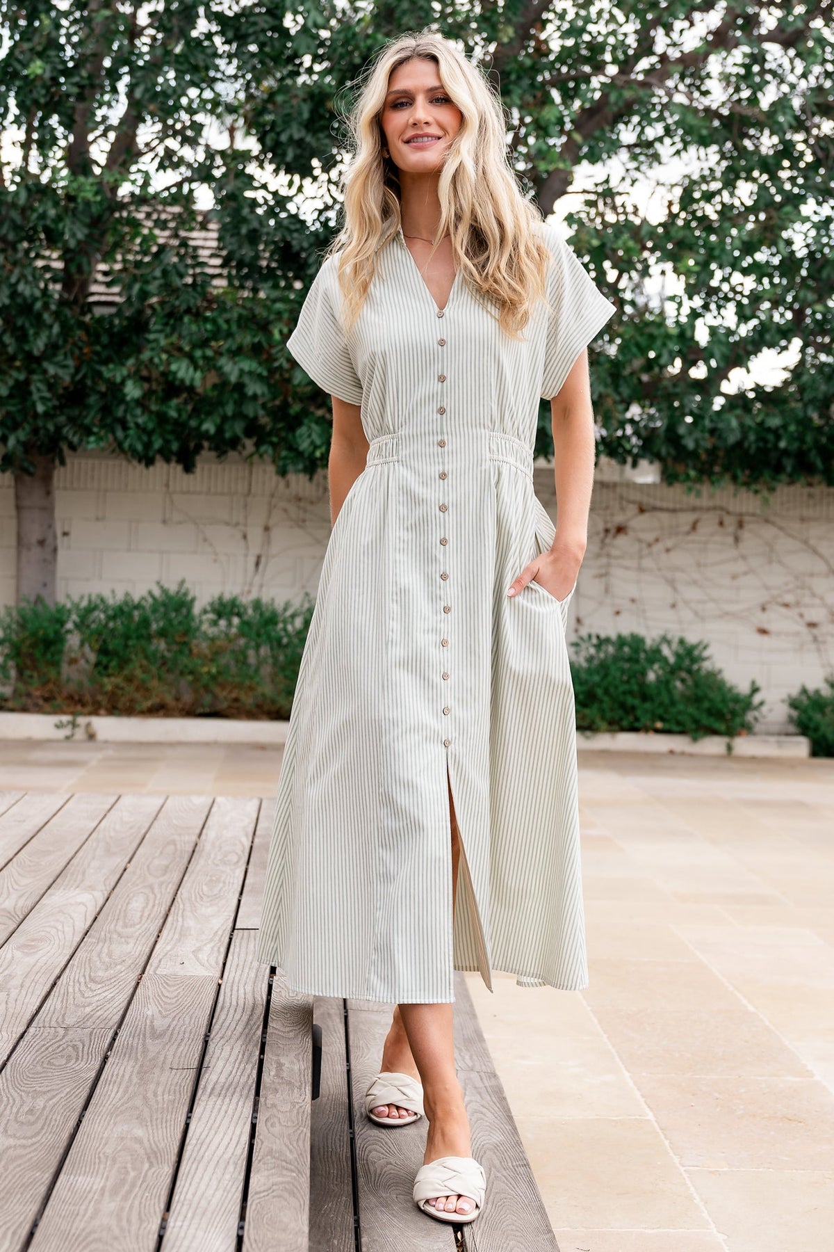 Front view of sage and off-white striped midi dress with collared V-neck, faux-button front, smocked back waist, and short cuffed sleeves.