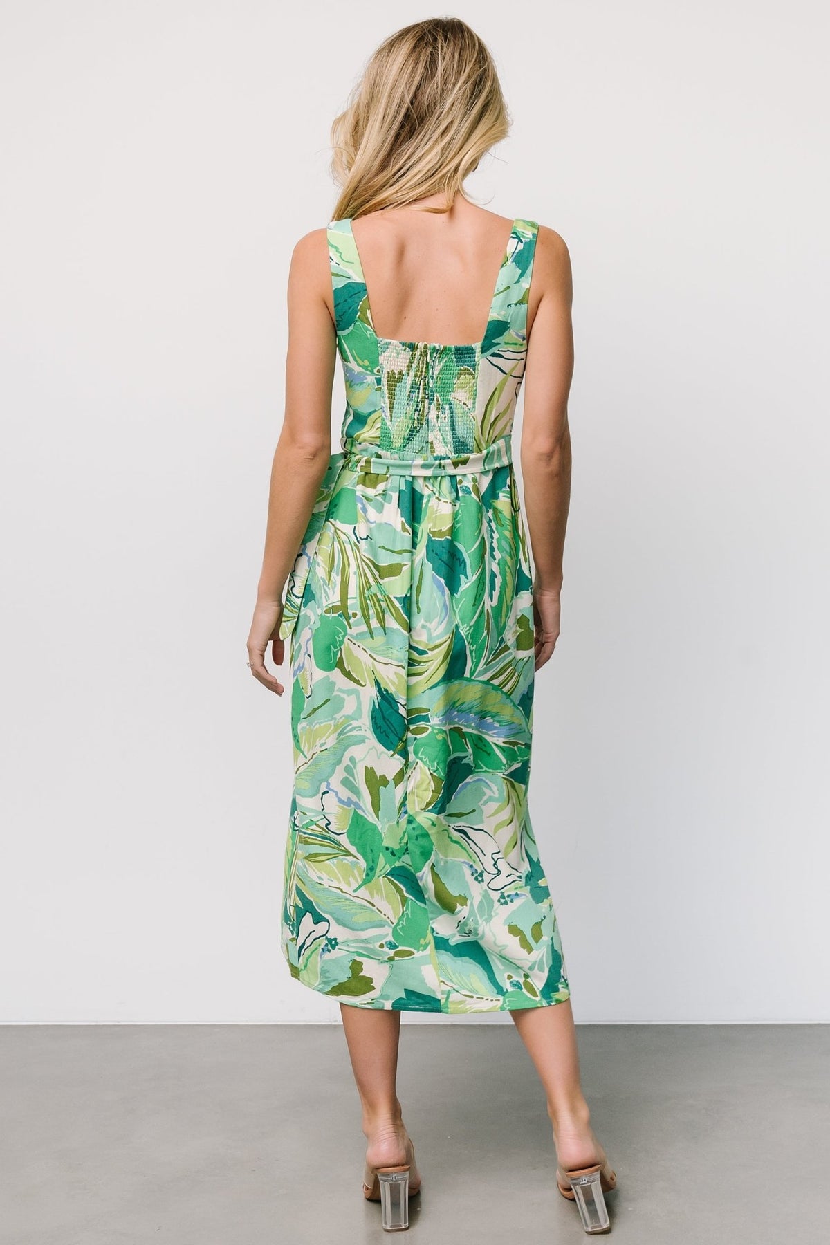 Model movement shot of Latonya faux wrap midi dress in green multi, showing silhouette, lining, and soft fabric movement.