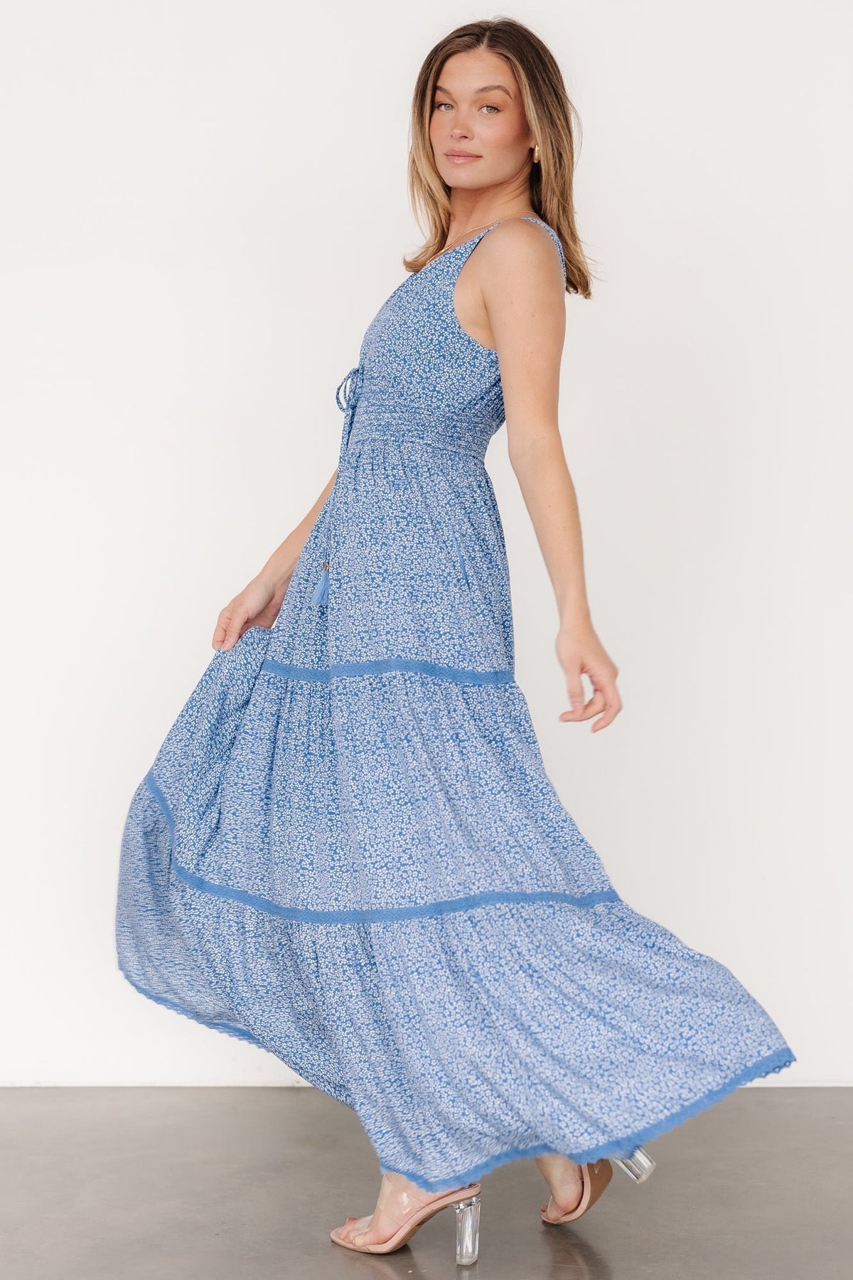 Detail view of lace-trimmed skirt tiers and partial lining edge on the blue floral maxi, emphasizing the airy rayon fabric and tiered construction.