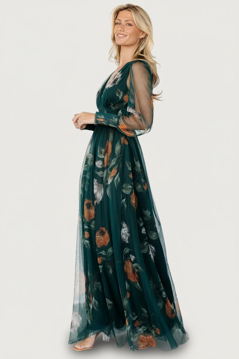 Model wearing deep Topaz floral tulle maxi dress with long smocked sleeves, sheer overlay and flattering A-line silhouette.