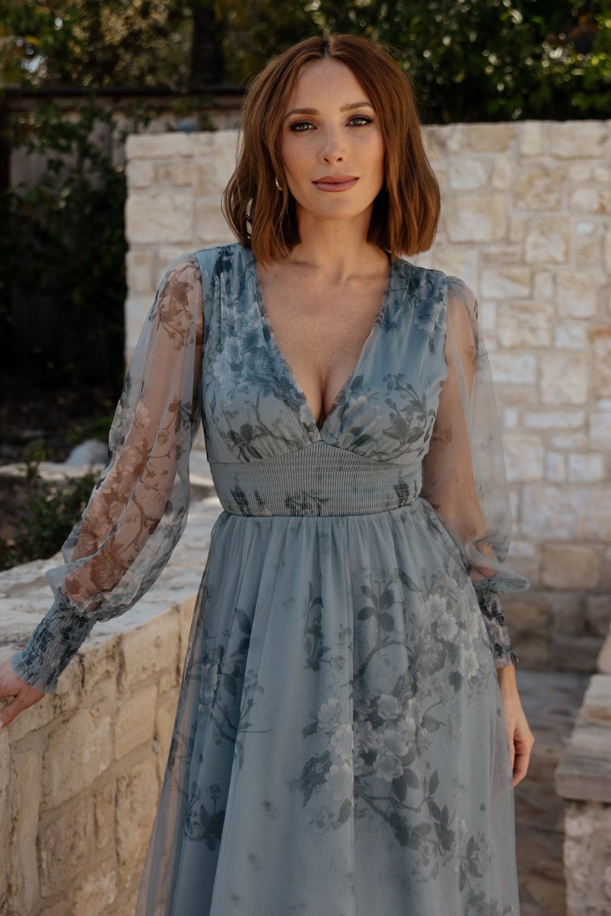 Model walking in dusty blue floral tulle maxi dress to show full skirt movement and how the fabric flows with steps.