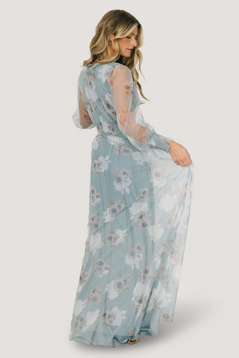 Side view of Layla tulle maxi in light blue floral showing sleeve silhouette, smocked cuff detail, and layered tulle panels on the skirt.