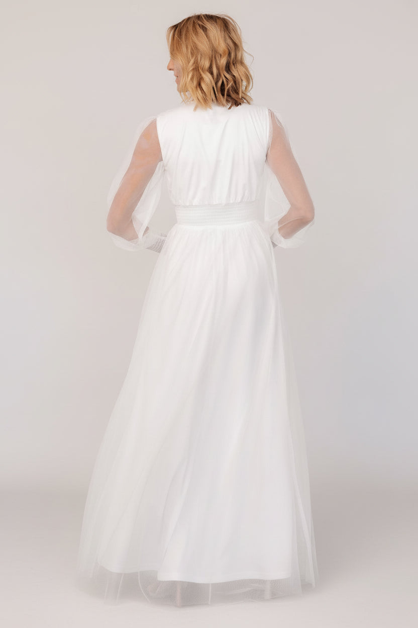 Back view of Layla Tulle Maxi Dress in white on model, displaying the flowing tulle skirt, raw hem and overall maxi length.