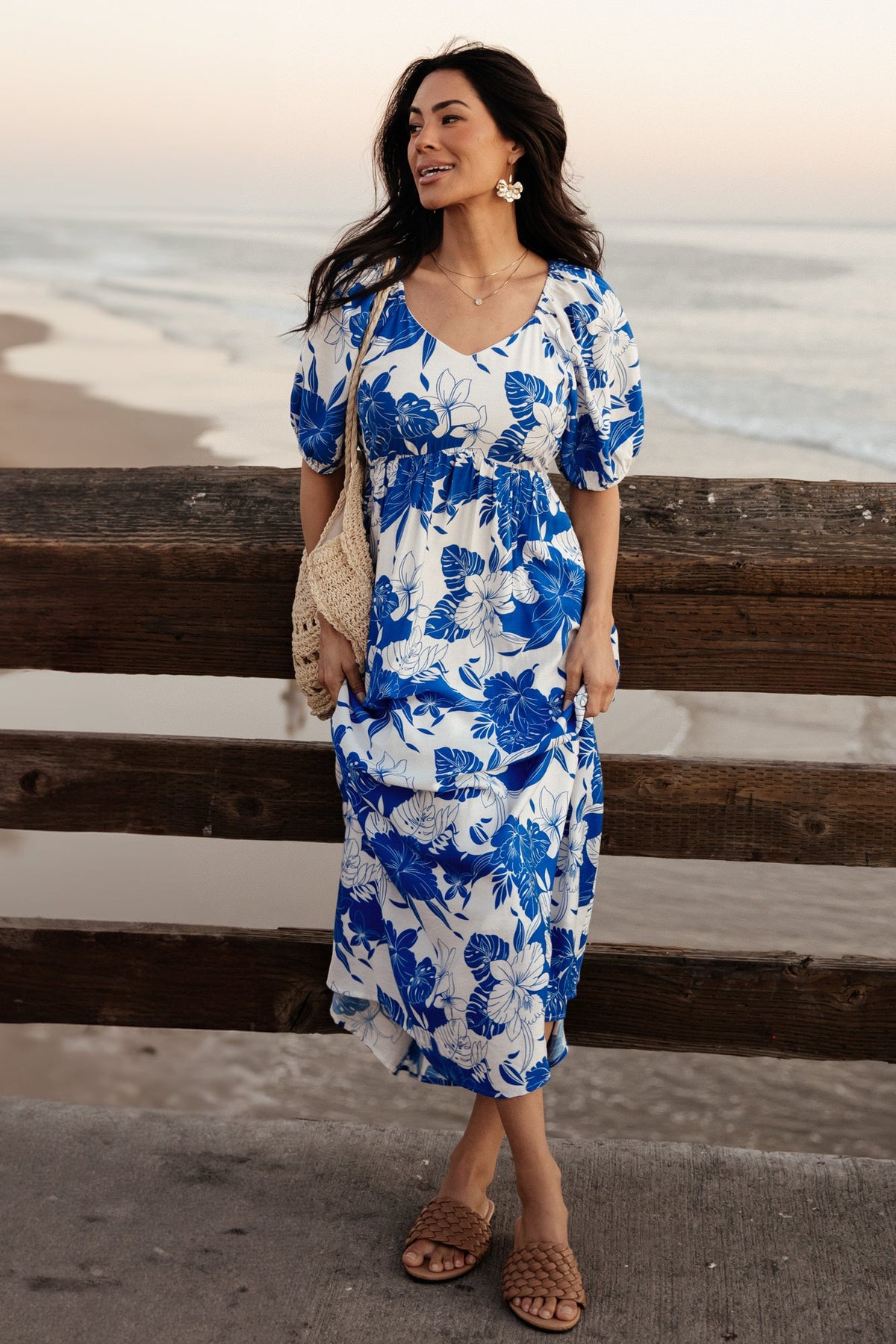 Front view of cobalt and off-white floral Leela maxi dress on model, showing V-neck, empire waist, and side pockets for practical style and coverage.