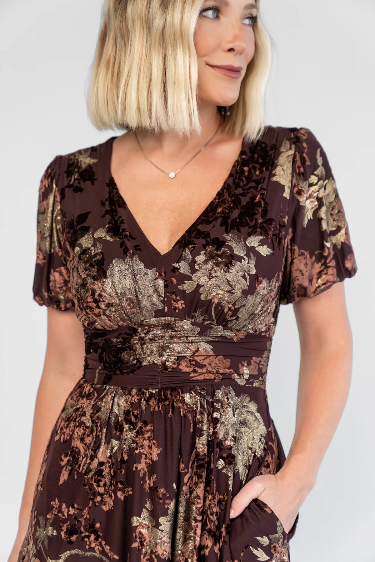 Leslie Velvet Maxi Dress in Brown + Metallic Gold with an embossed velvet floral design, a V-neckline, and puff sleeves.