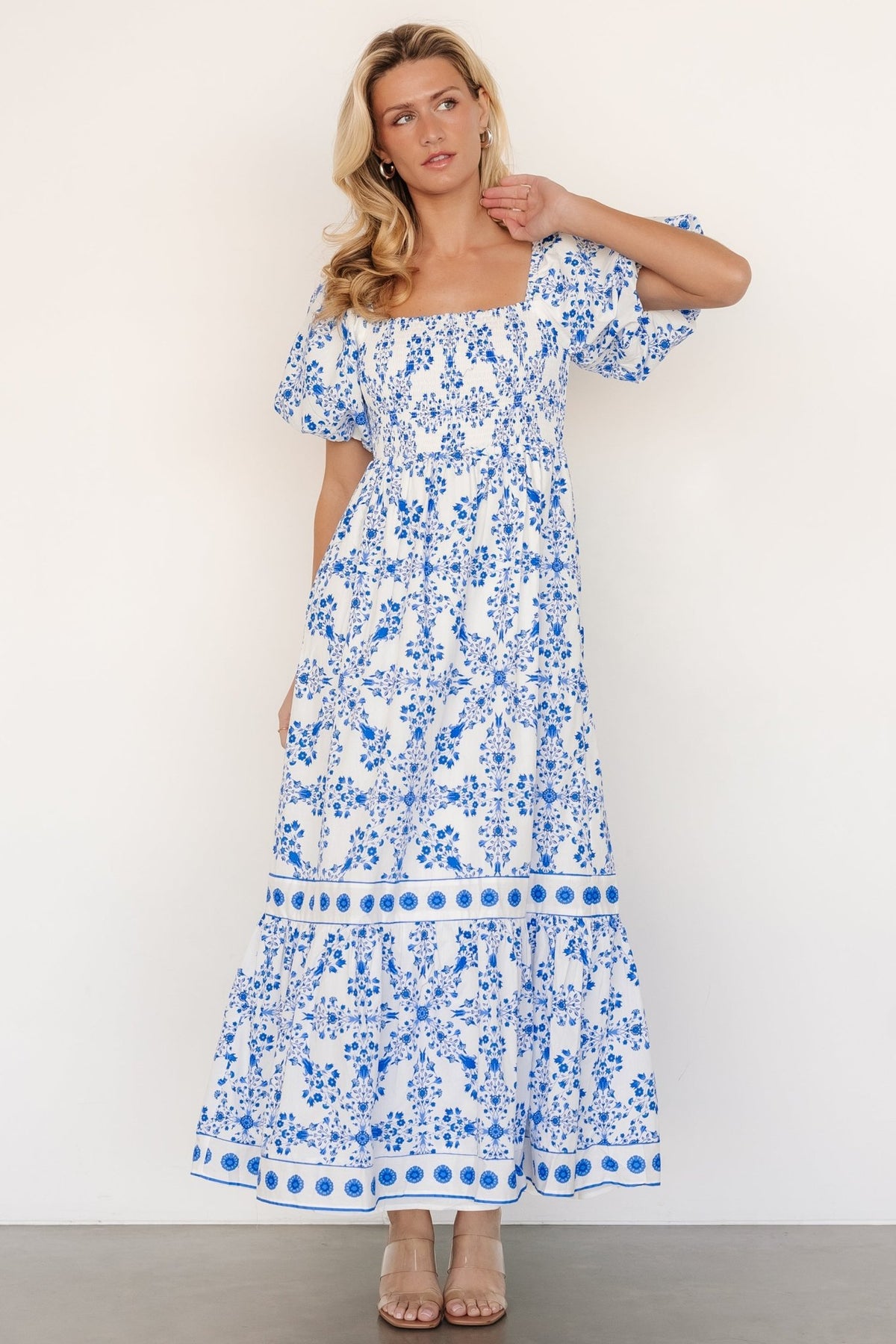 Detail shot of oversized puff sleeve with elastic cuff and the lightweight cotton weave in an off-white base with blue florals.