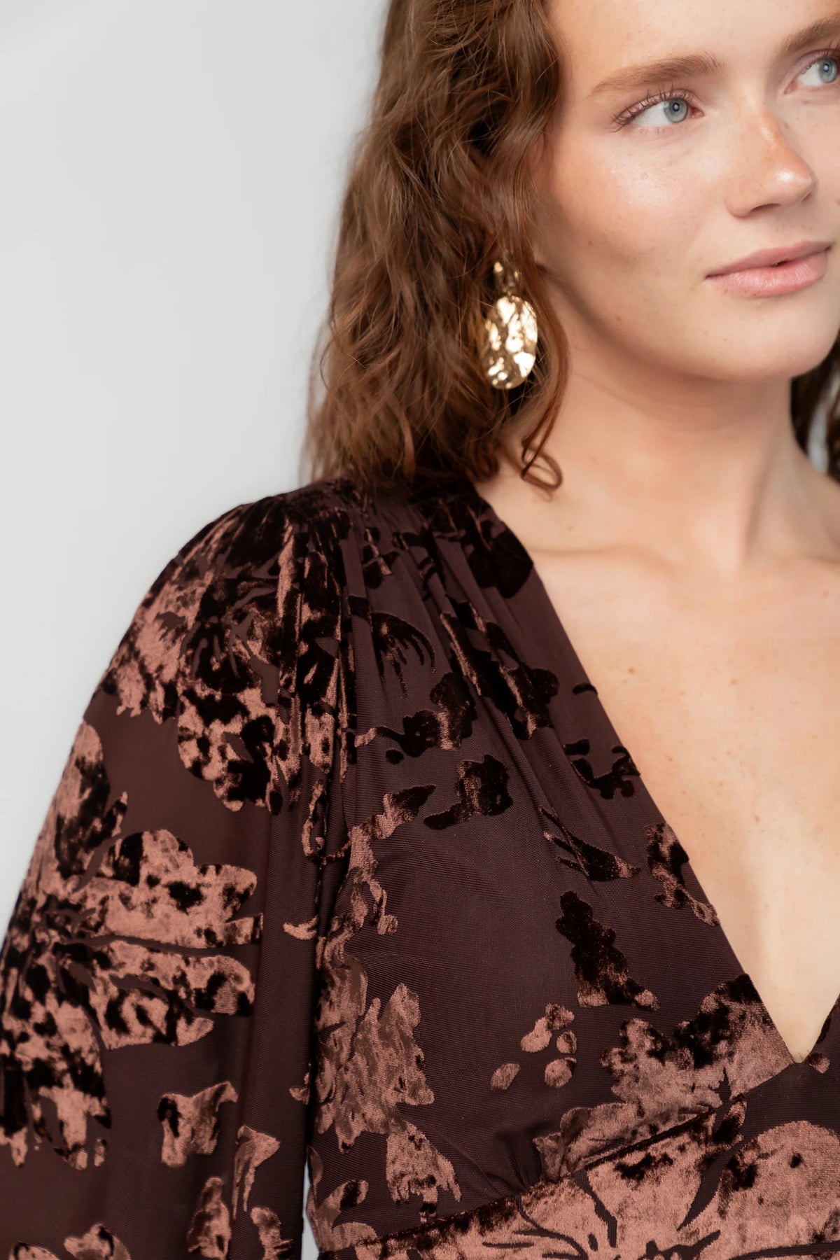 Liana Velvet Embossed Ruffle-Tier Maxi Dress in Brown with V-neck, long sleeves, elastic waist, and tiered skirt.