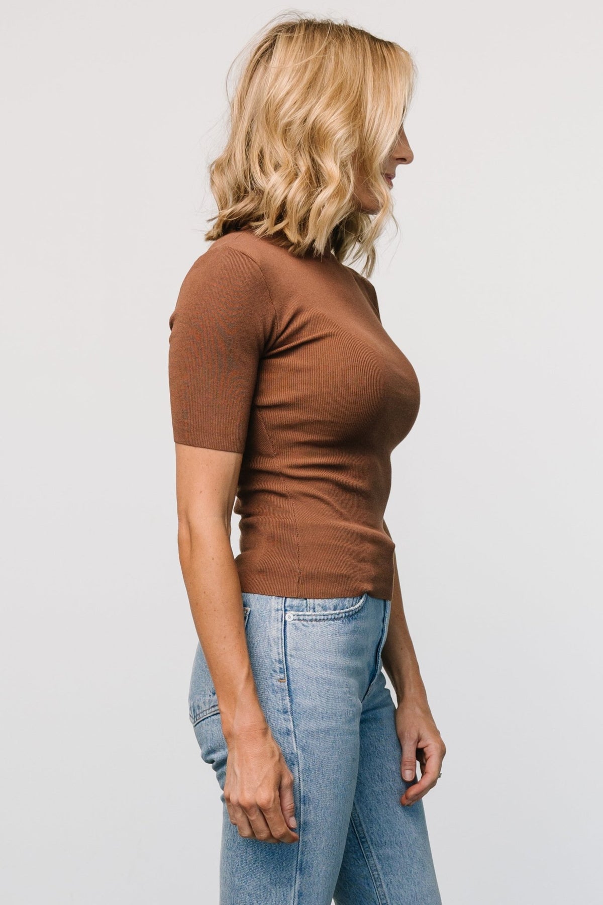 Side view of Libby Ribbed Knit Top in warm brown, highlighting the close-to-body silhouette, short sleeve length, and ribbed stretch fabric.