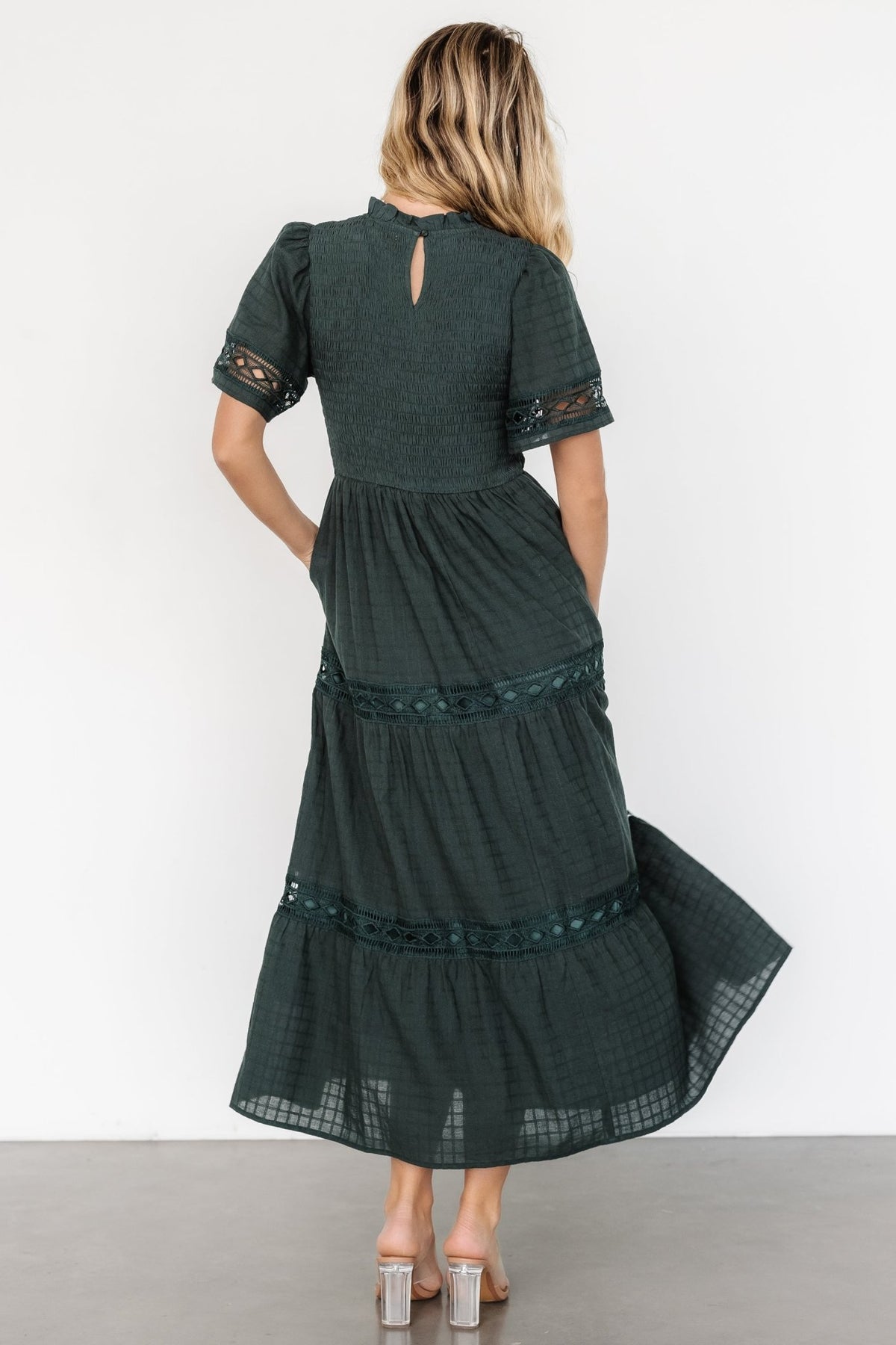 Back view of the maxi dress showing keyhole and button closure at the neckline, ruffled collar, and the upper smocked bodice.