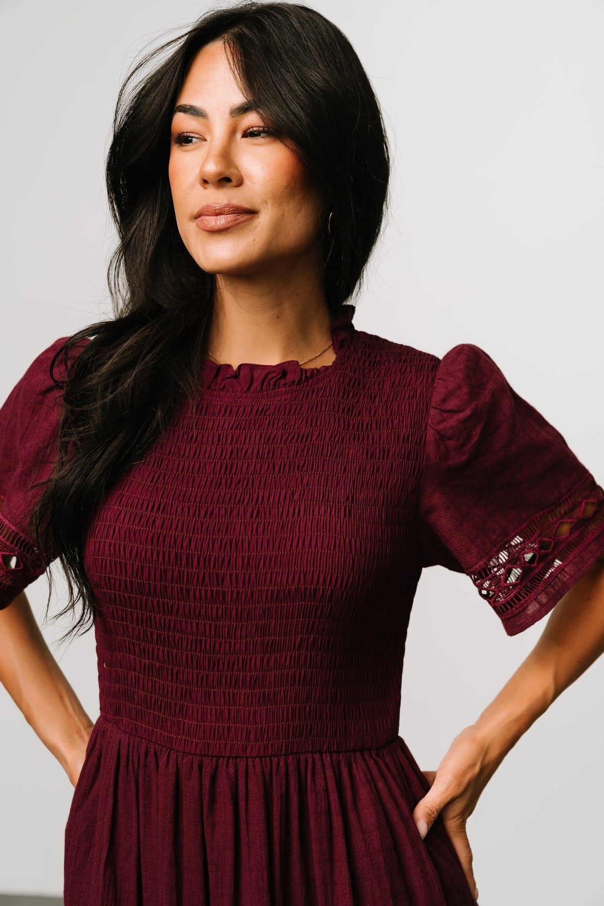 Back detail of dress showing keyhole closure with button and ruffled neckline, plus the lined interior at the upper back.