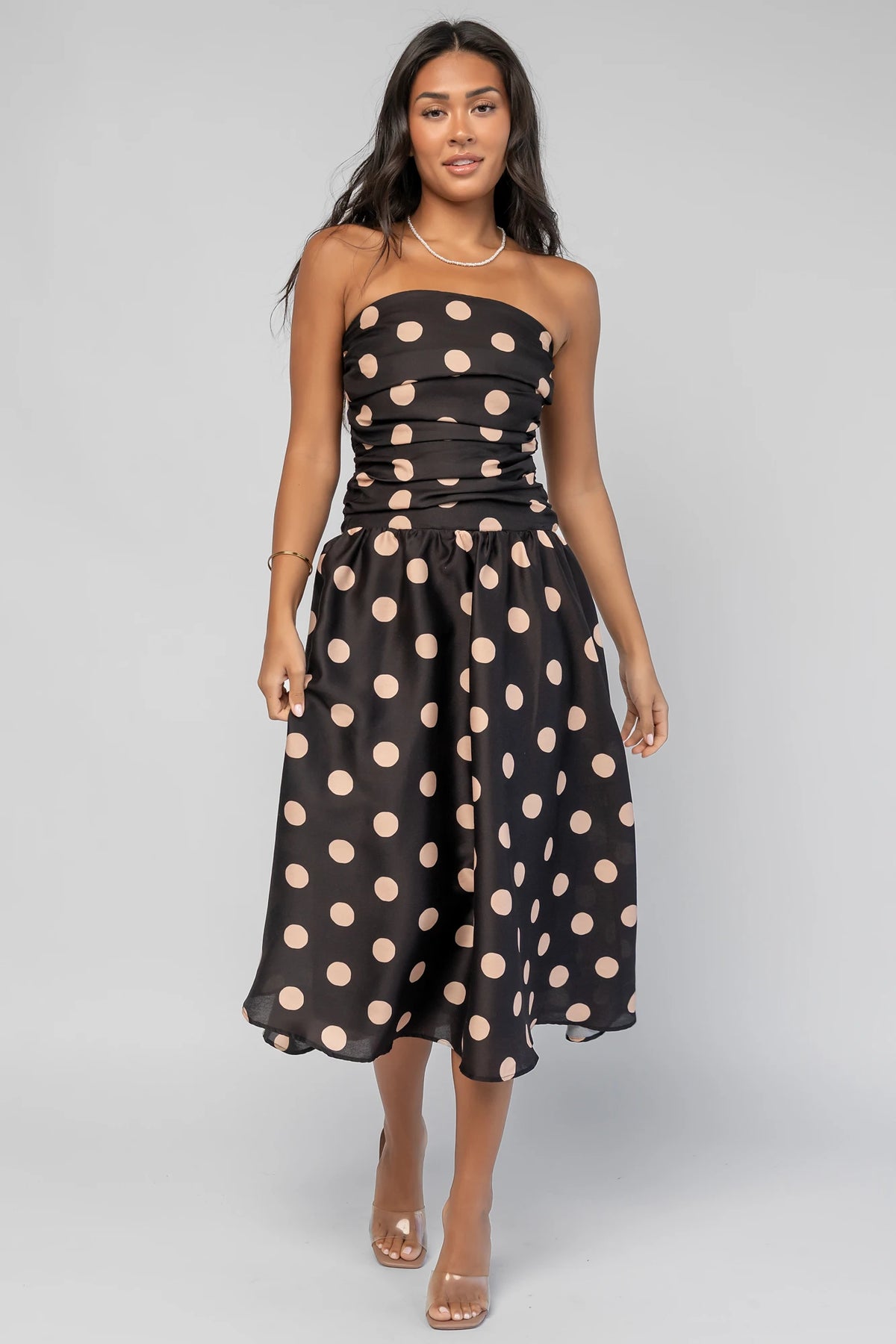 Lucienne Strapless Midi Dress in Black + Beige Dot with strapless neckline, cinched bodice, smocked back, and dropped waist.