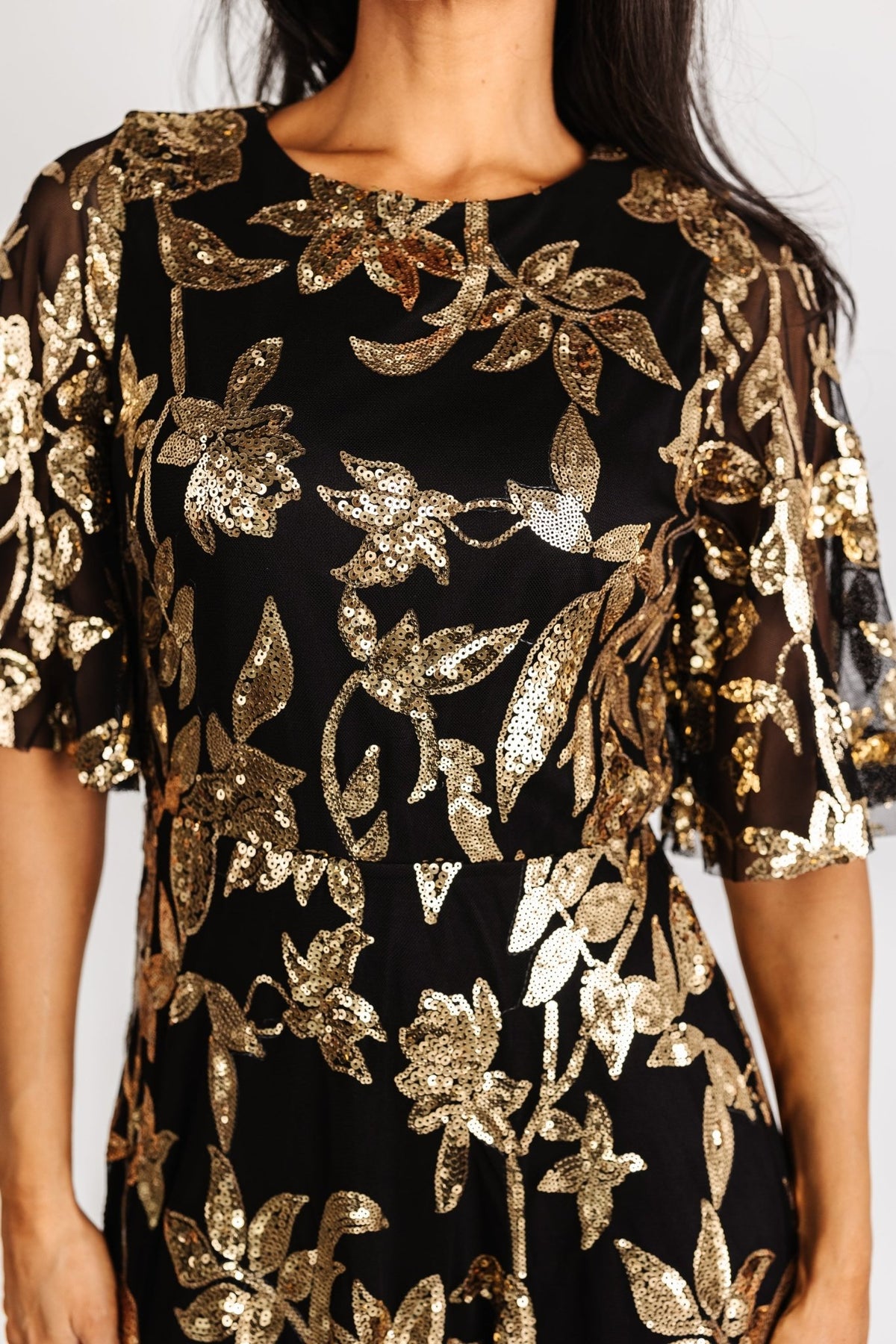 Three-quarter angle of Lucy Sequin Dress highlighting gold sequin pattern on black tulle overlay and the soft drape of the lined skirt.
